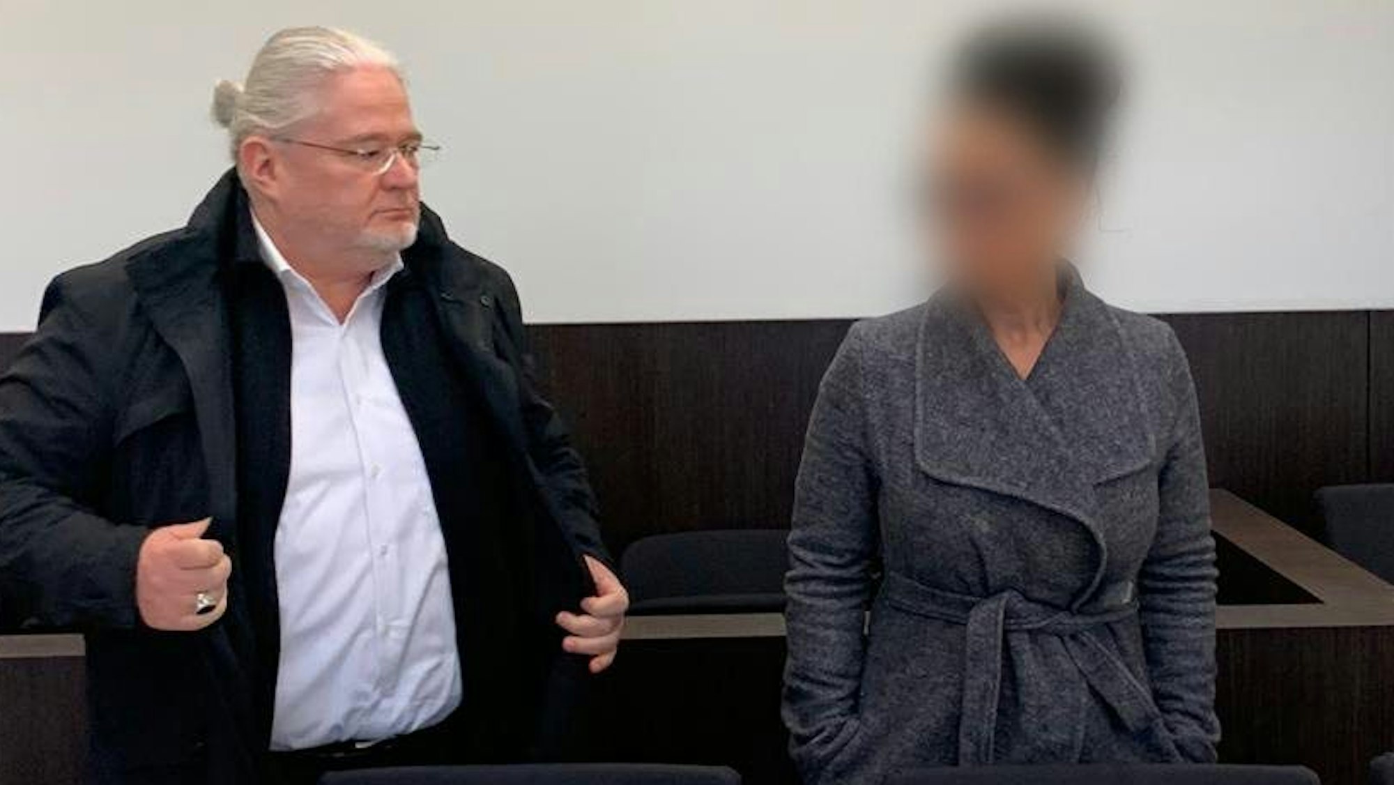 Die Angeklagte steht in einem Saal des Düsseldorfer Amtsgerichts neben ihrem Anwalt.