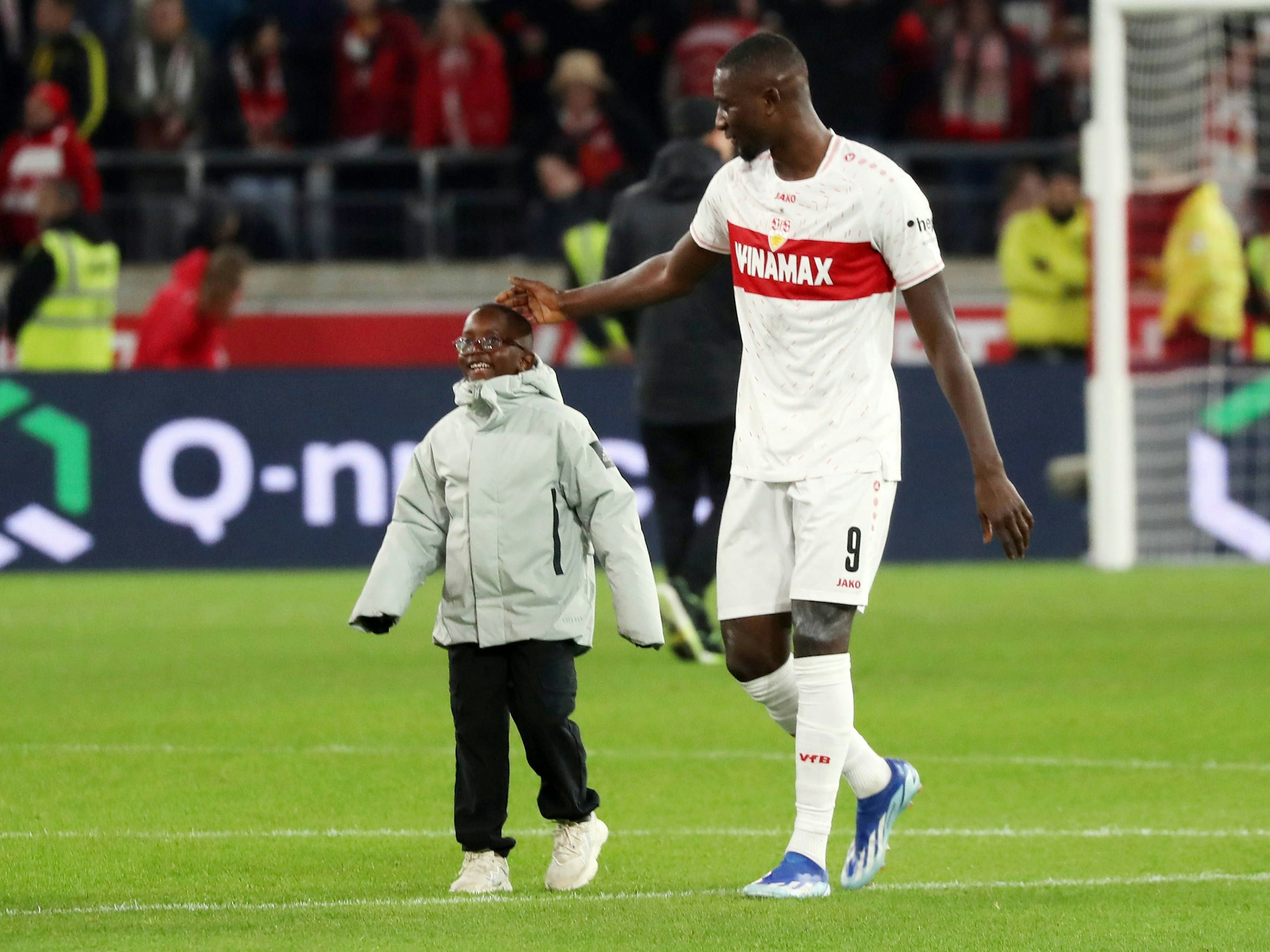 Serhou Guirassy geht mit seinem Sohn über das Spielfeld.