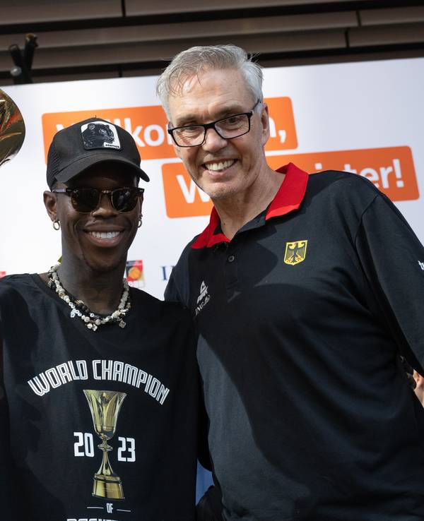 Dennis Schröder (l), Kapitän der Basketball-Nationalmannschaft, und Bundestrainer Gordon Herbert jubeln mit dem WM-Pokal.