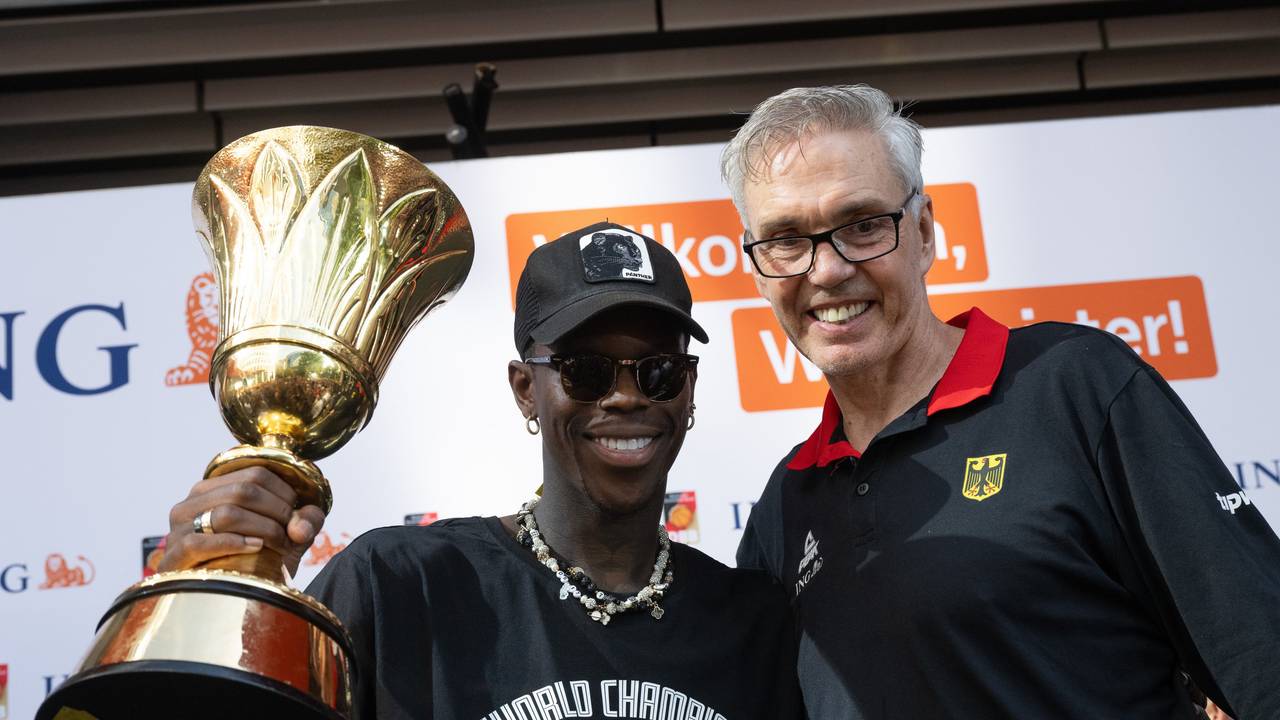 Dennis Schröder (l), Kapitän der Basketball-Nationalmannschaft, und Bundestrainer Gordon Herbert jubeln mit dem WM-Pokal.