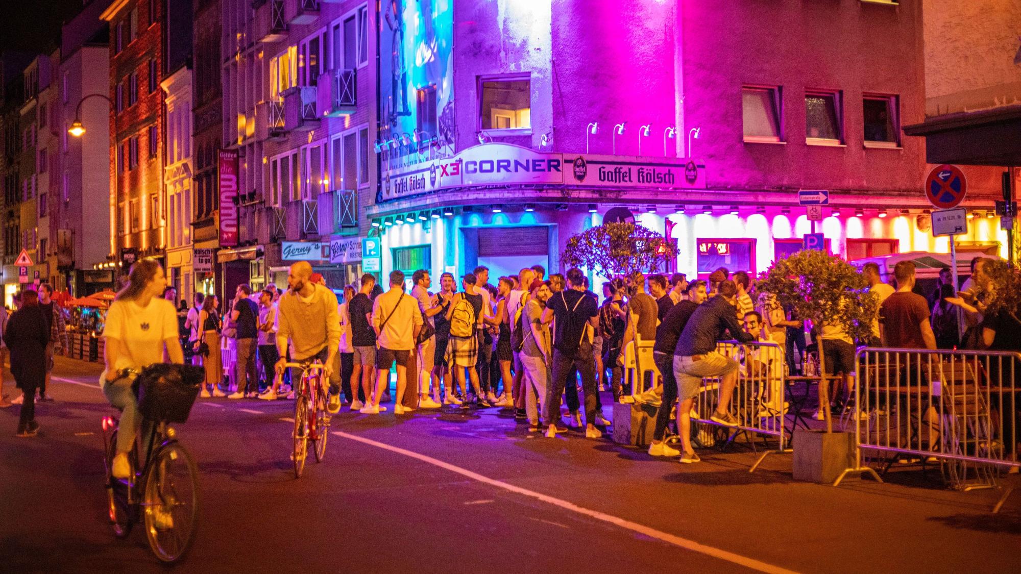 Feierlichkeiten auf der Kölner Schaafenstraße, Menschen warten vor dem Eingang eines Lokals auf Einlass.