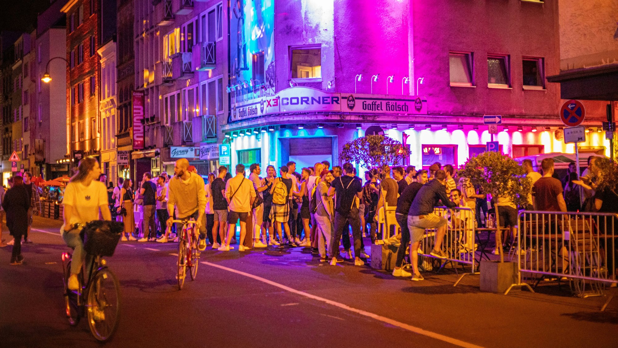 Feierlichkeiten auf der Kölner Schaafenstraße, Menschen warten vor dem Eingang eines Lokals auf Einlass.