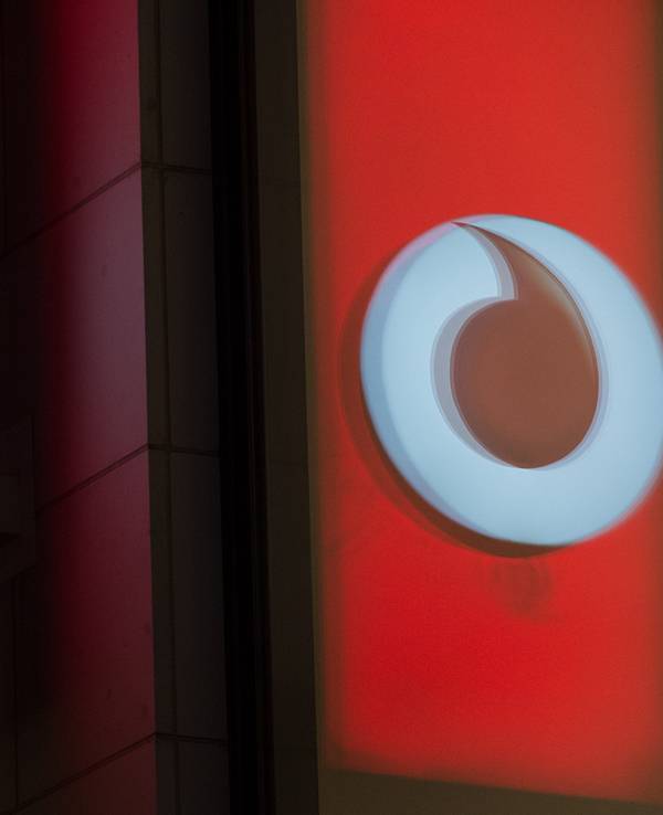 Das Logo von Vodafone spiegelt sich in der Fensterscheibe einer Verkaufsfiliale des Unternehmens in der Kölner Innenstadt. Der Internet-Anbieter drehte an der Preisschraube, nun wurde eine Sammelklage eingereicht.