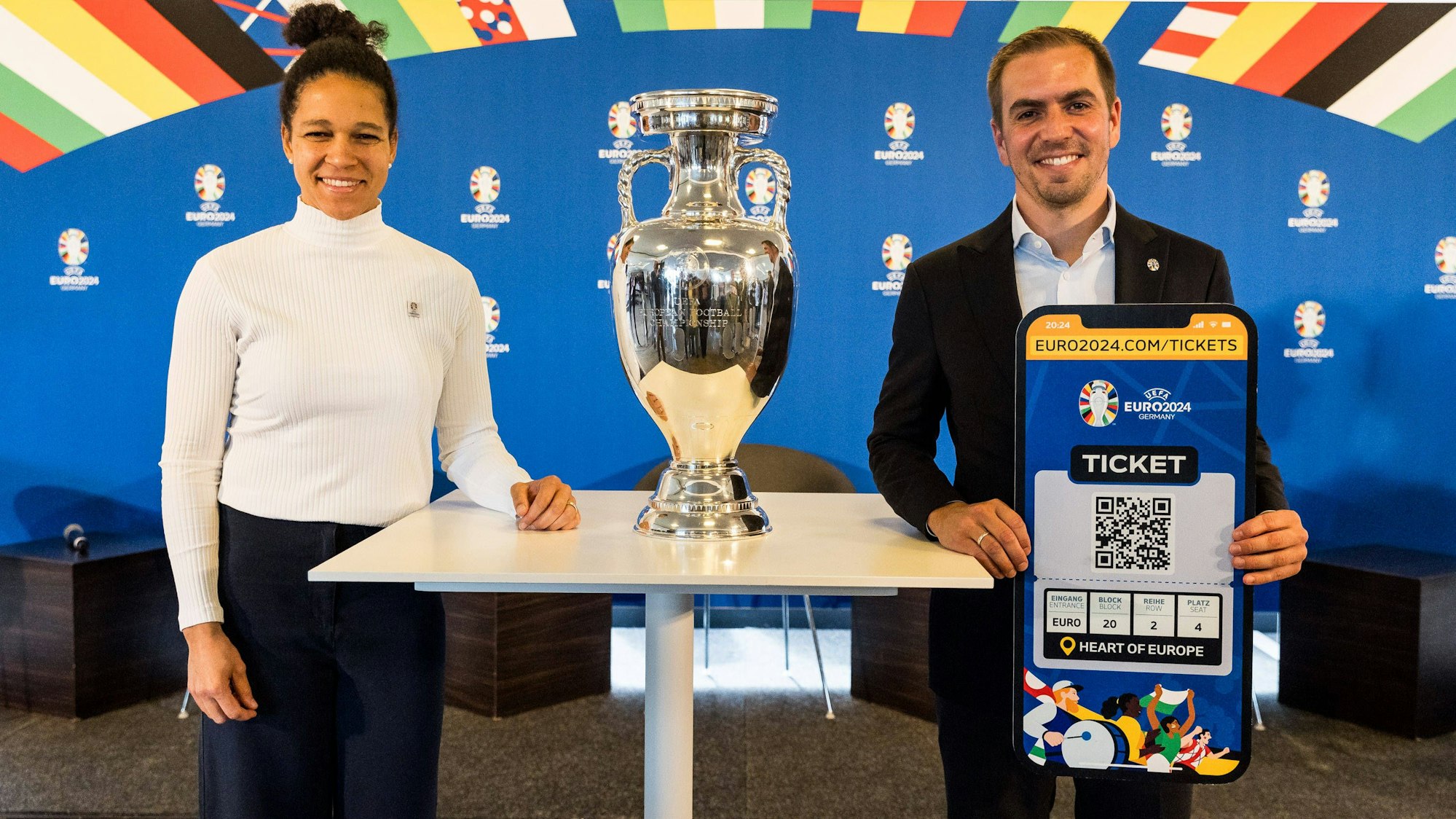 Philipp Lahm und Celia Sasic posieren mit dem EM-Pokal und einer Papp-Version eines EM-Tickets.
