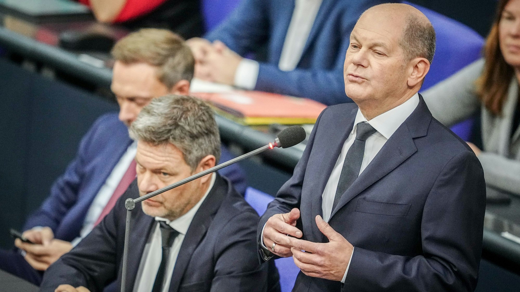 Bundeskanzler Olaf Scholz (r., SPD) spricht bei der Regierungsbefragung im Bundestag neben Finanzminister Christian Lindner (l., FDP) und Wirtschaftsminister Robert Habeck (Mitte, Bündnis 90/Die Grünen).