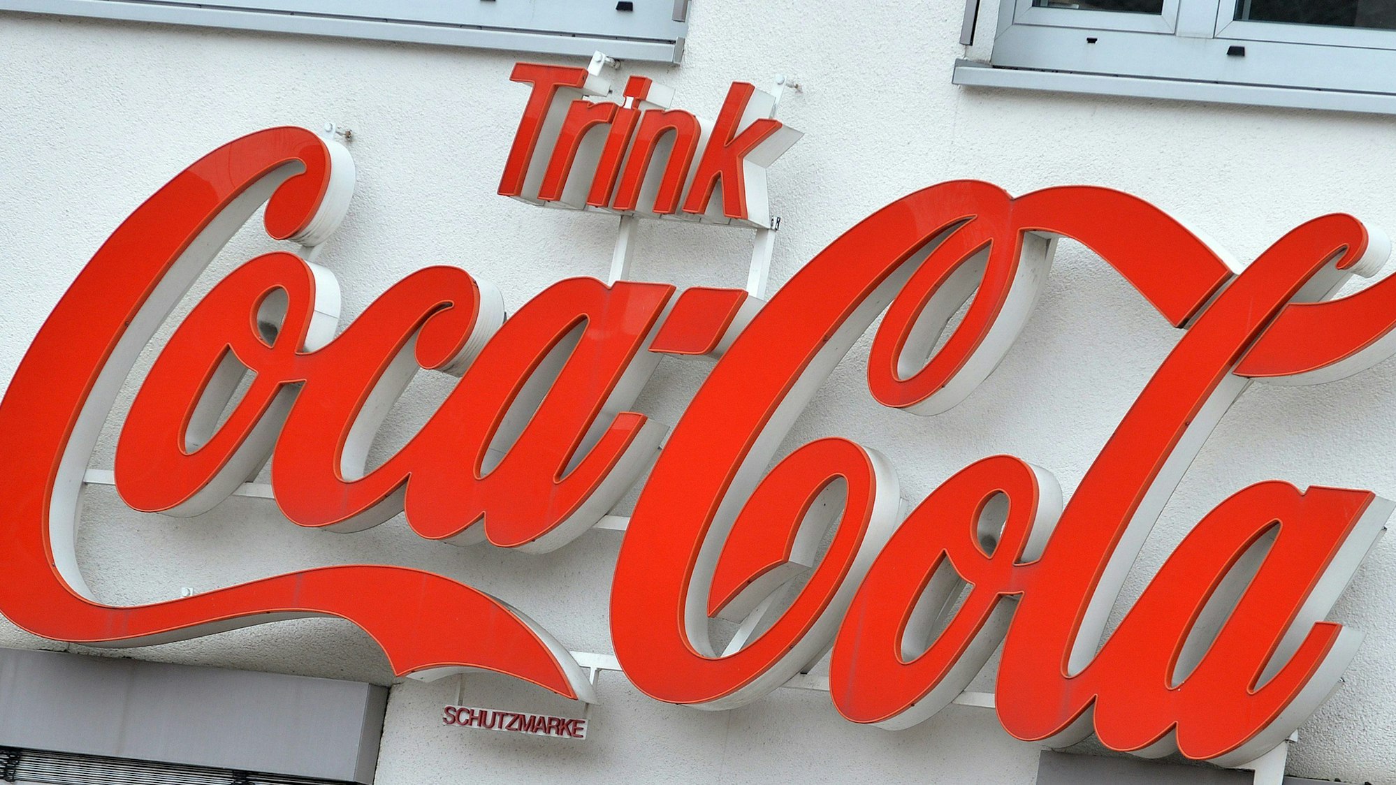 Der Schriftzug „Trink Coca-Cola“ steht an einem Gebäude der Verwaltung des Getränkeherstellers Coca-Cola.