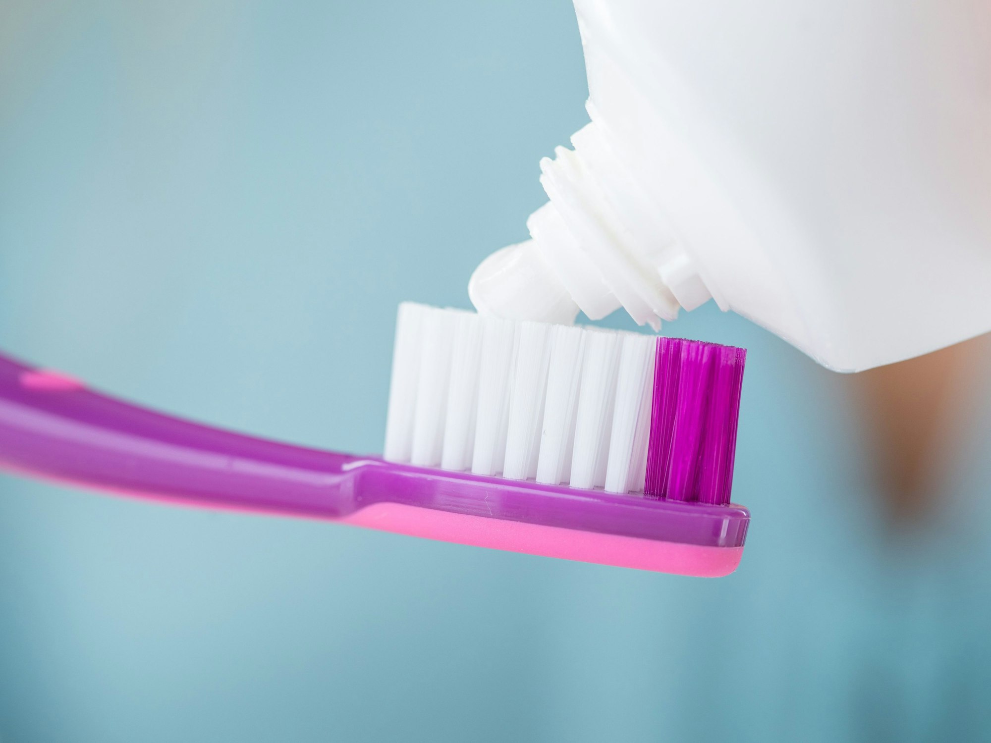 Zahncreme wird auf eine Zahnbürste gegeben.