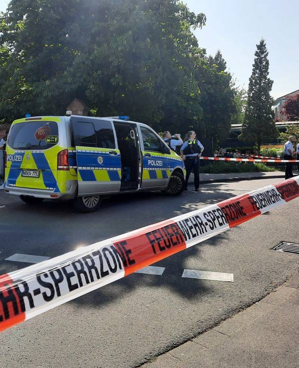 Einsatzkräfte der Polizei steht an einem abgesperrten Bereich.
