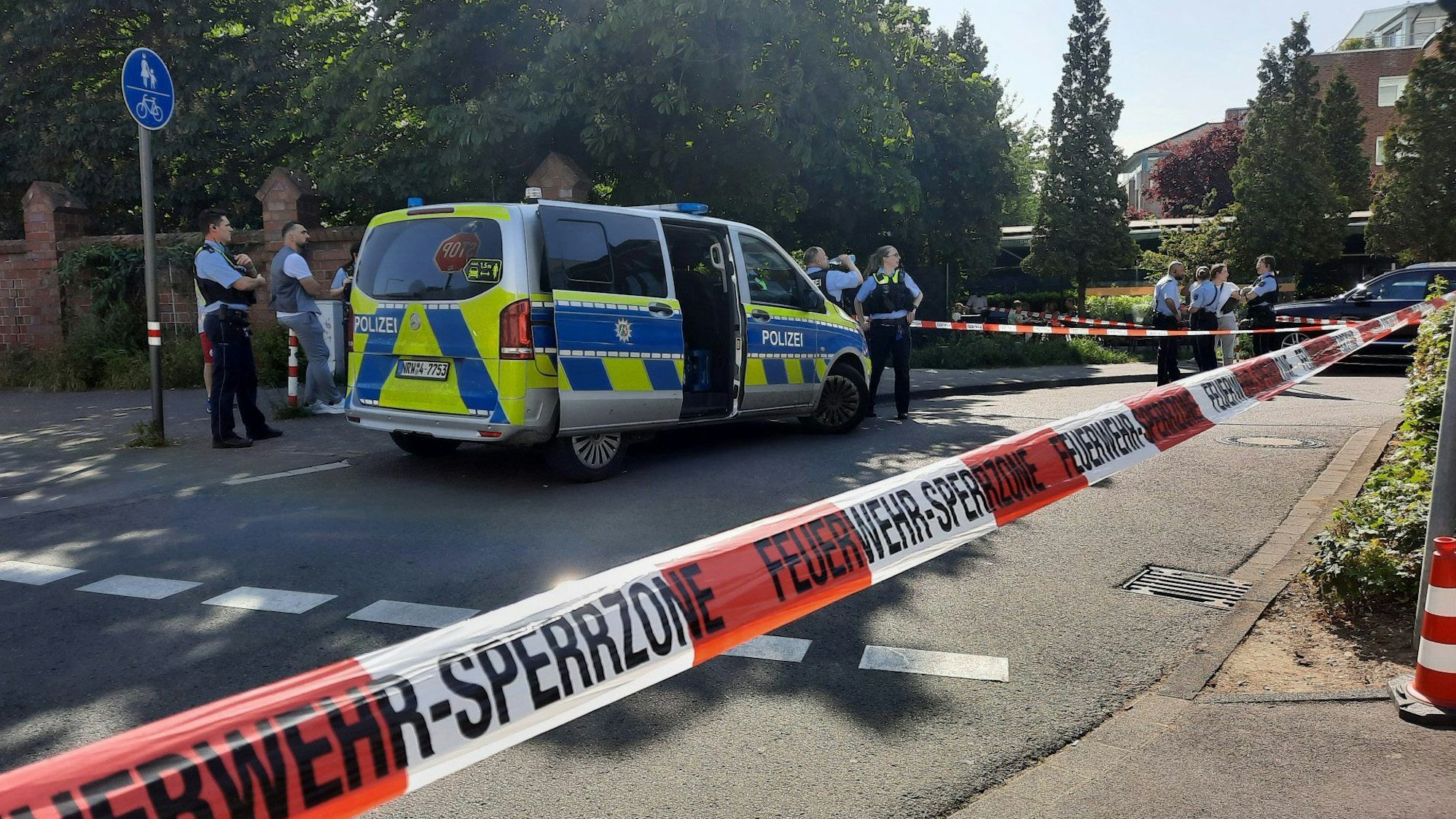 Polizistinnen und Polizisten stehen an einem abgesperrten Bereich.