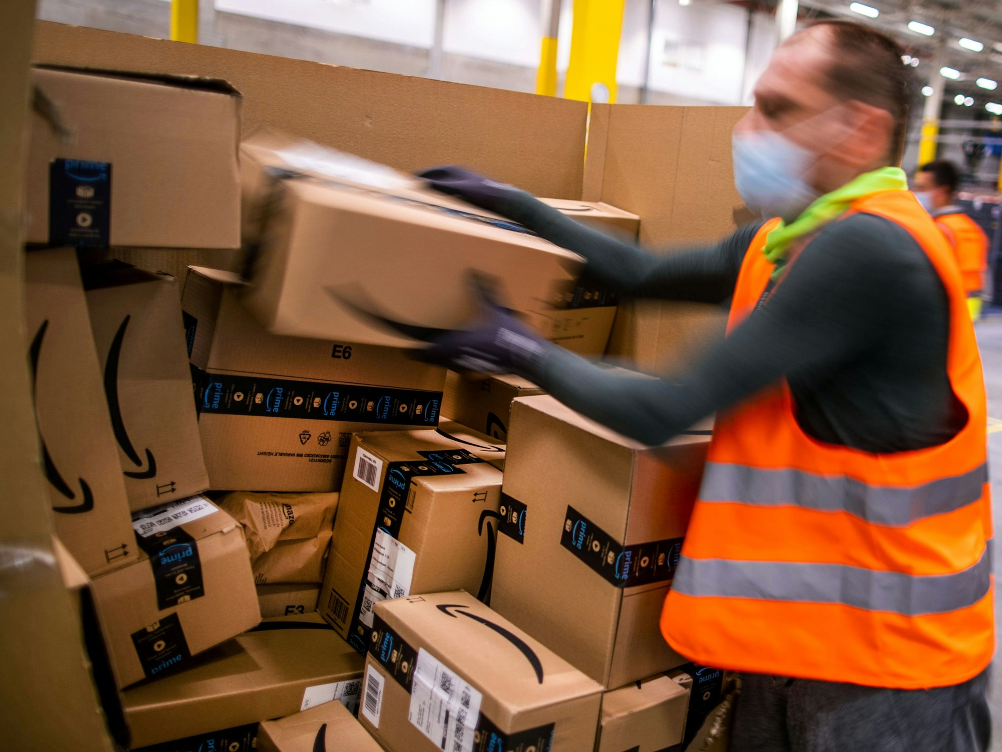 Ein Mitarbeiter sortiert an einem Transportband Paketsendungen in einem Verteilzentrum des Online-Händlers Amazon in Mecklenburg-Vorpommern.