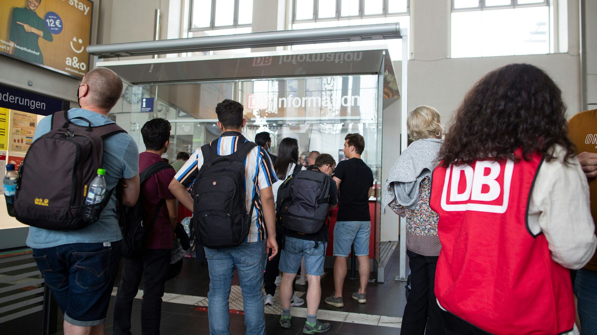 Einige Menschen gehen mit Taschen und Rucksäcken durch den Hauptbahnhof in Dortmund.
