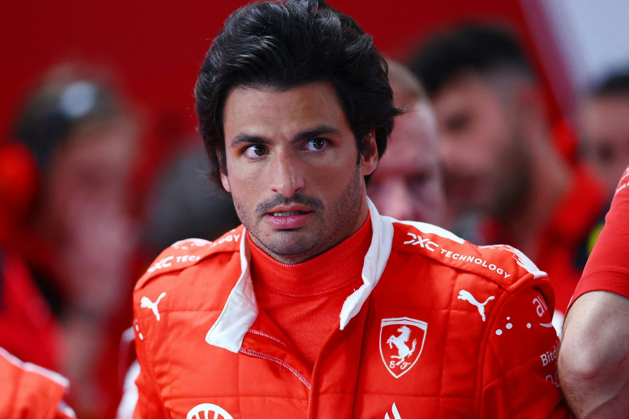 Ferrari-Pilot Carlos Sainz steht in der Boxengasse von Ferrari.