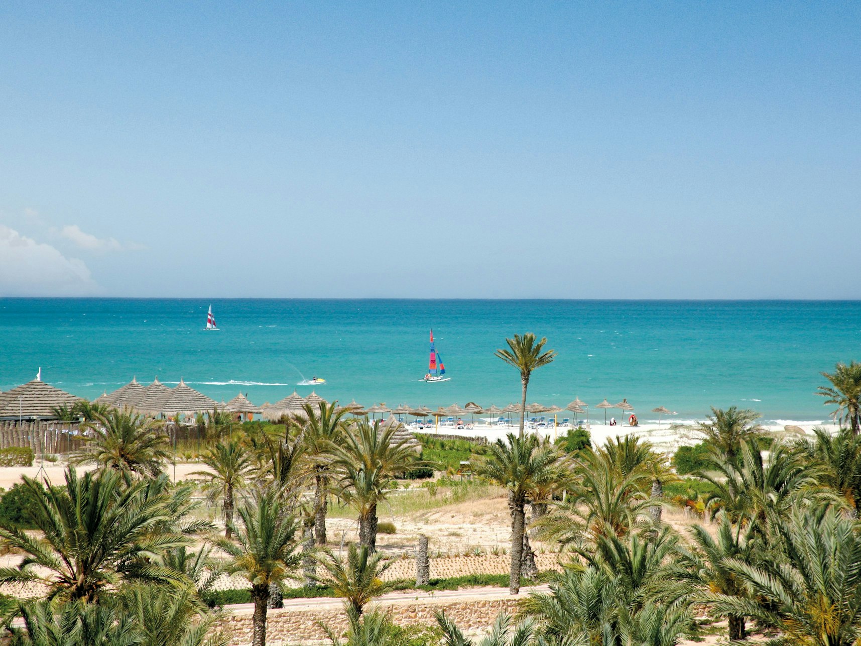 Das Foto zeigt einen Strand mit Palmen und türkisblauem Meer auf der Insel Djerba in Tunesien, aufgenommen im März 2016.
