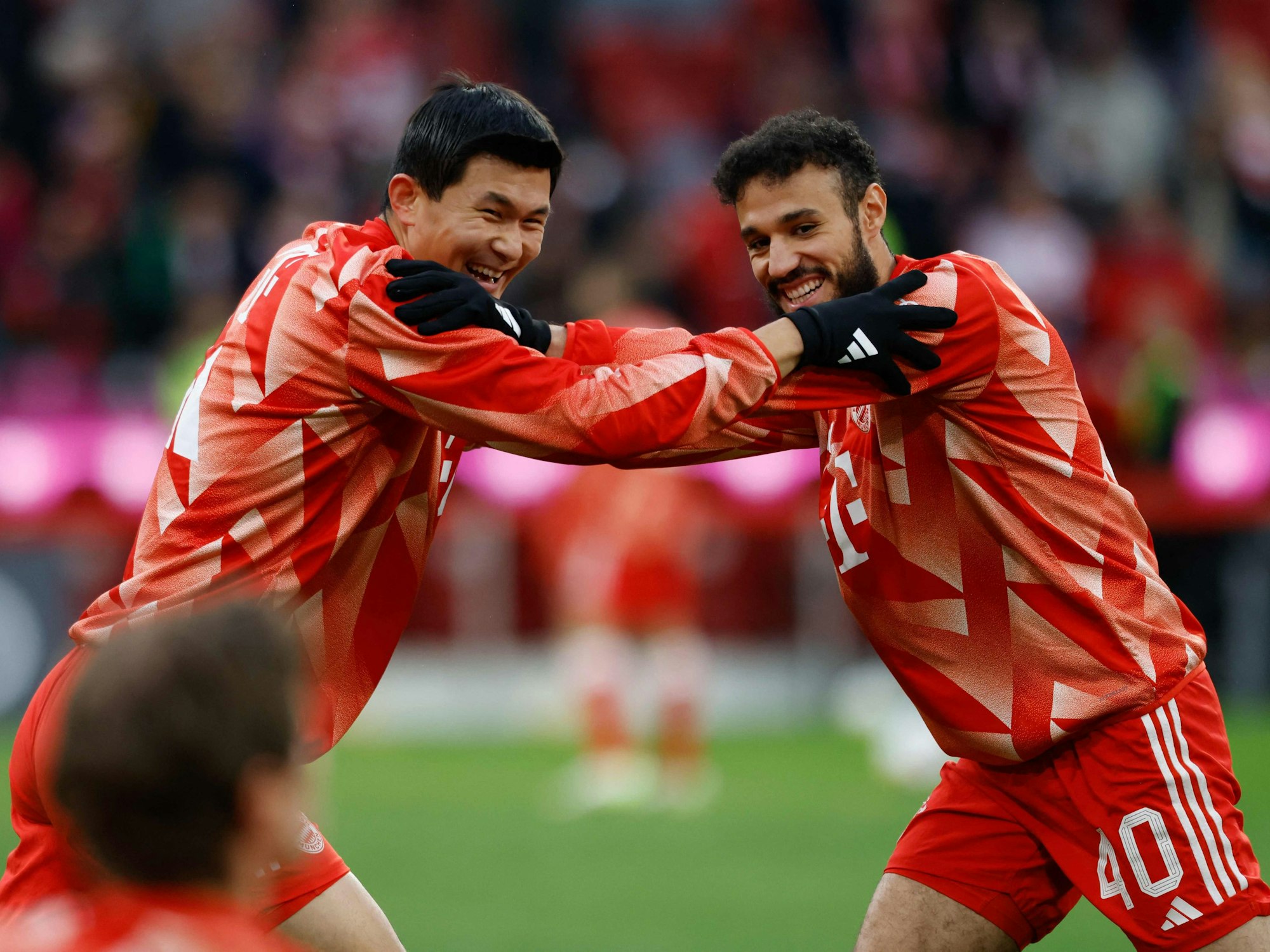 Min-jae Kim (l.) und Noussair Mazraoui wärmen sich vor dem Spiel des FC Bayern auf.