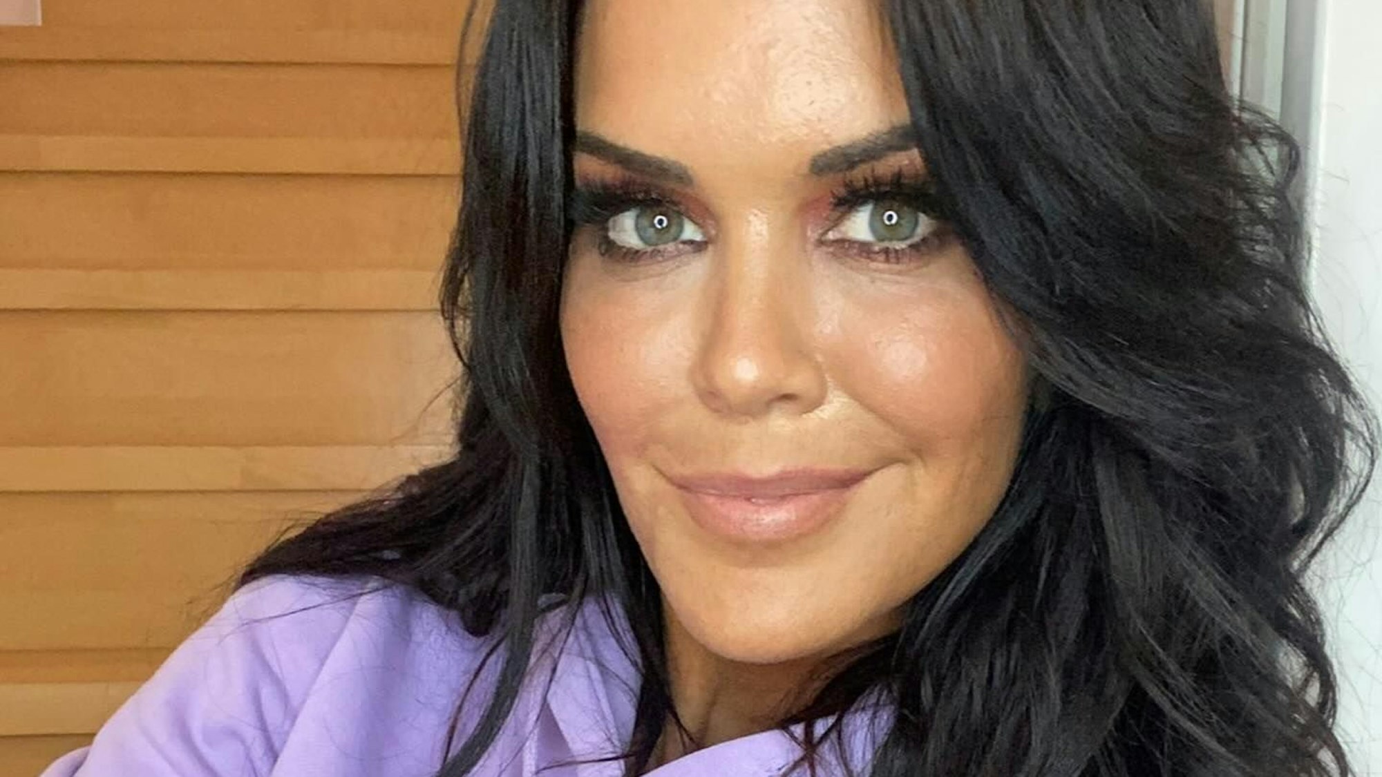 Martina Reuter trägt einen lilafarbenen Pullover und lächelt in die Kamera.