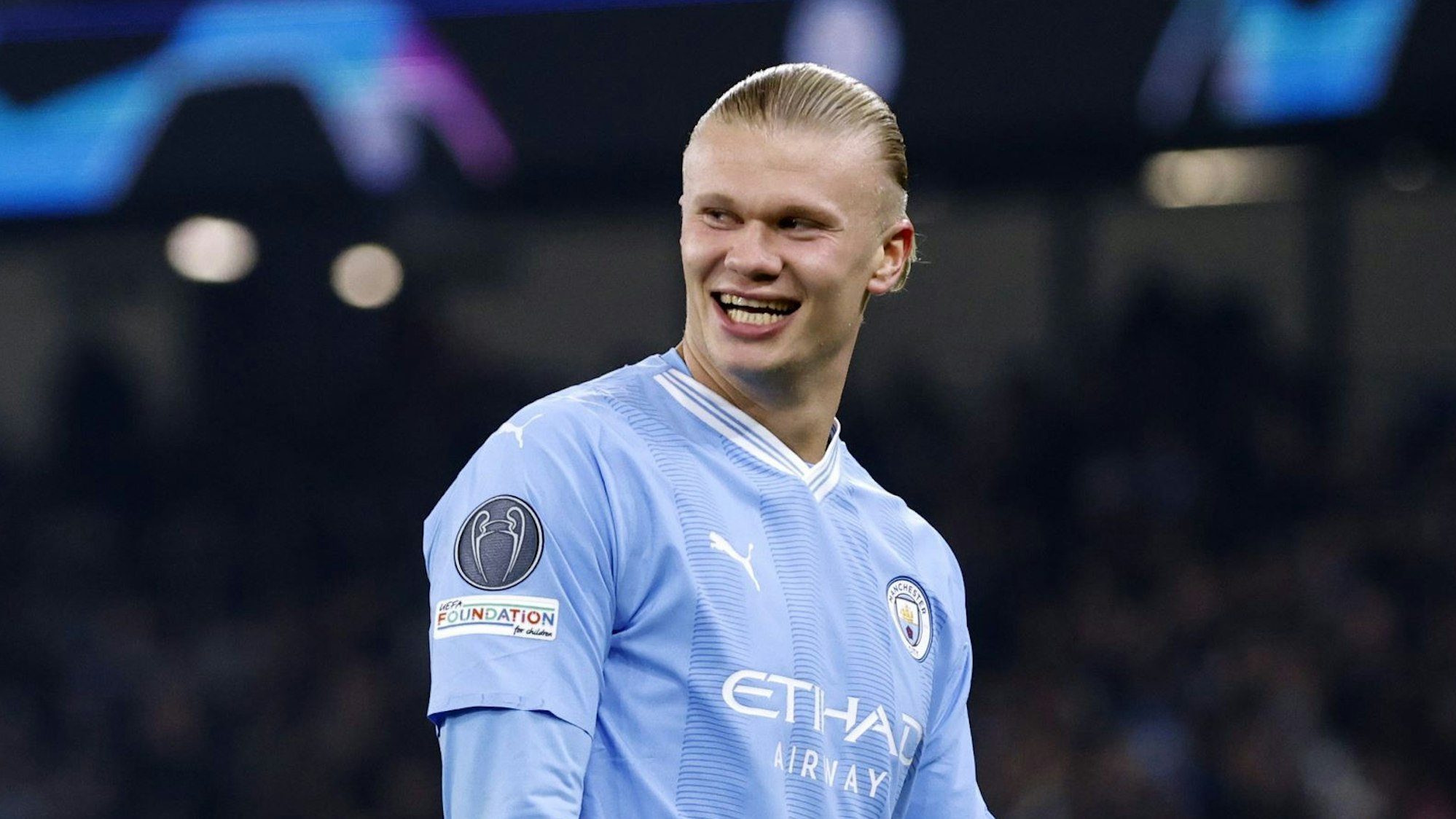 Erling Haaland lacht während eines Fußballspiels von Manchester City.