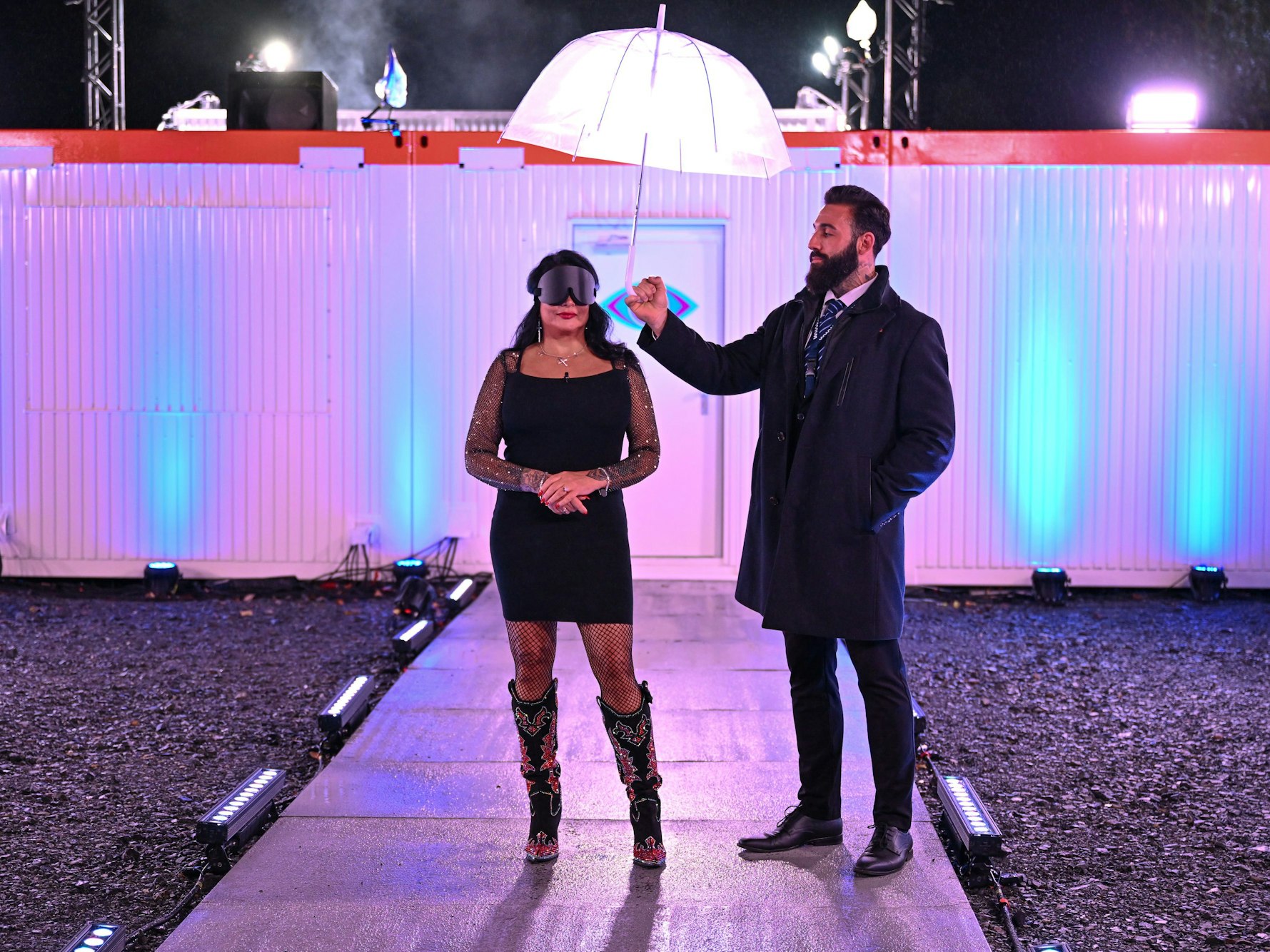 Iris Klein steht mit verbundenen Augen vor dem Container.