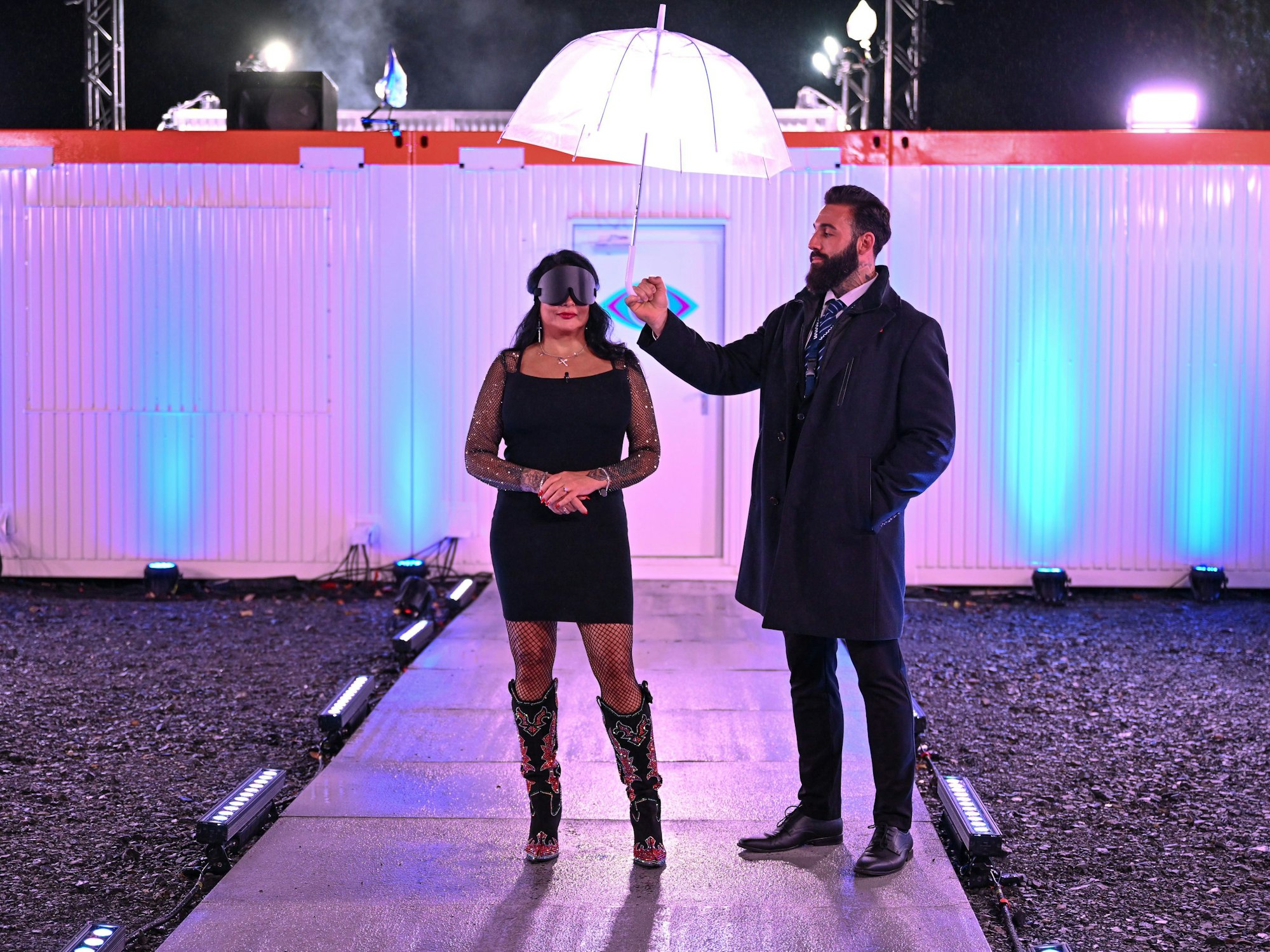 Iris Klein steht mit verbundenen Augen vor dem Container.