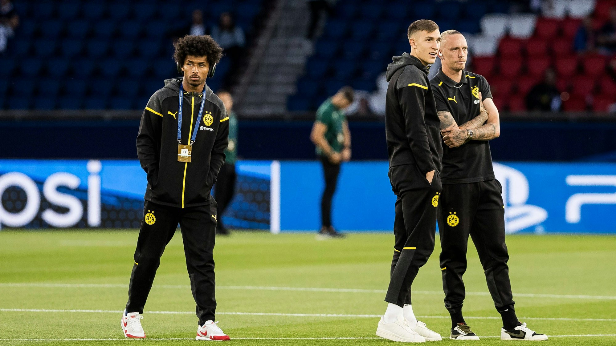 Karim Adeyemi, Nico Schlotterbeck und Marius Wolf vor einem Champions-League-Spiel auf dem Rasen.