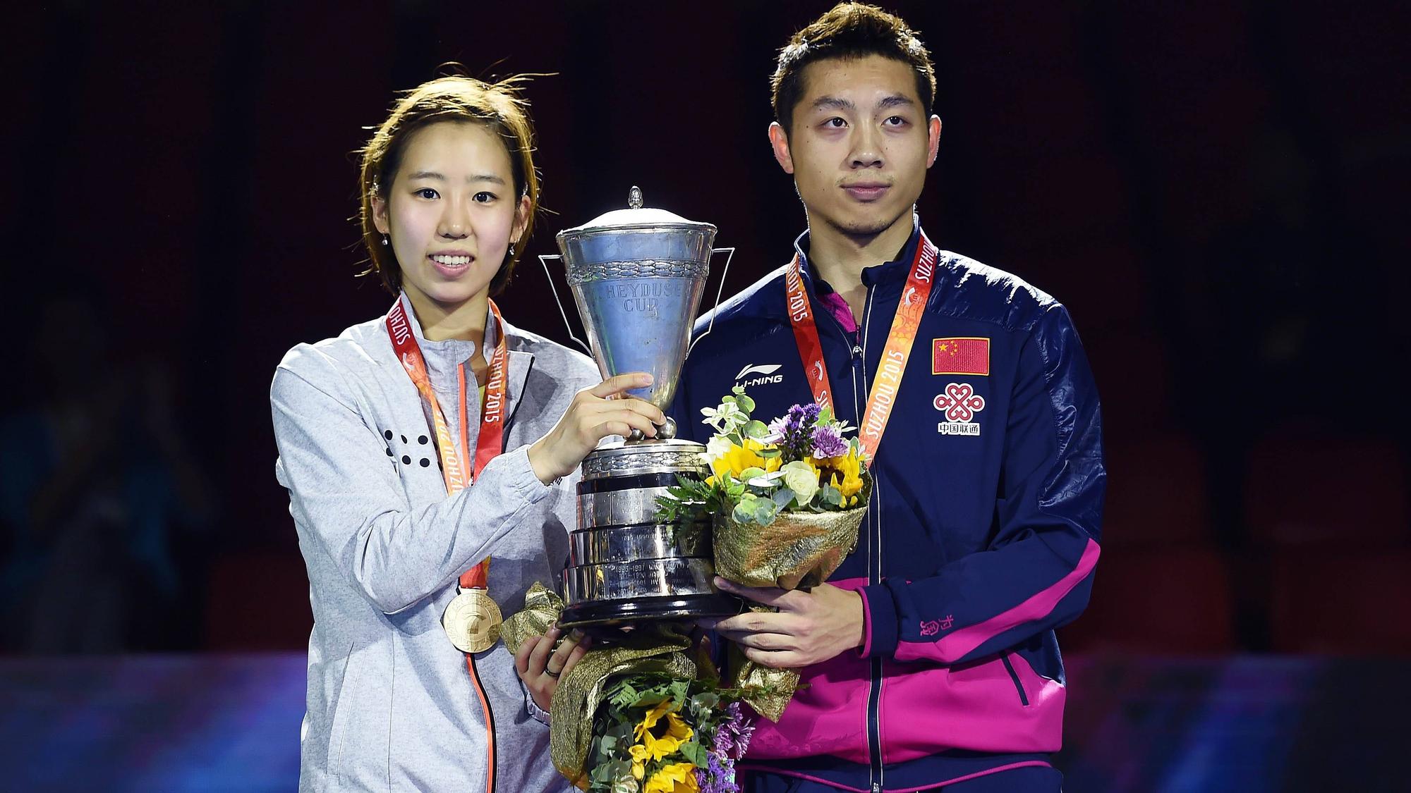 Chinas Xu Xin (li.) hält die Trophäe zusammen mit Südkoreas Yang Haeun (r.).
