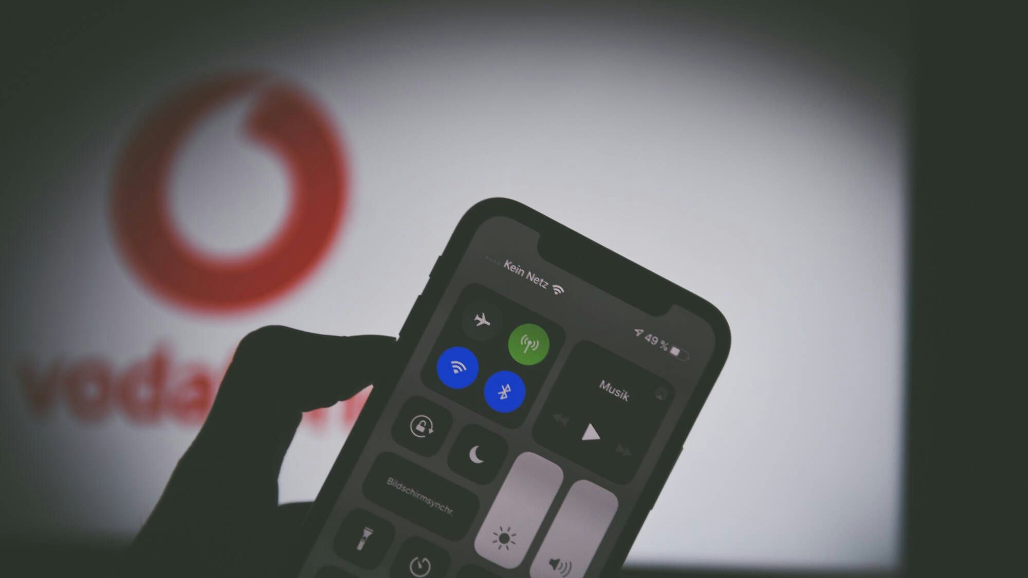 Ein Smartphone hat kein Netz. Im Hintergrund sieht man das Vodafone-Logo.