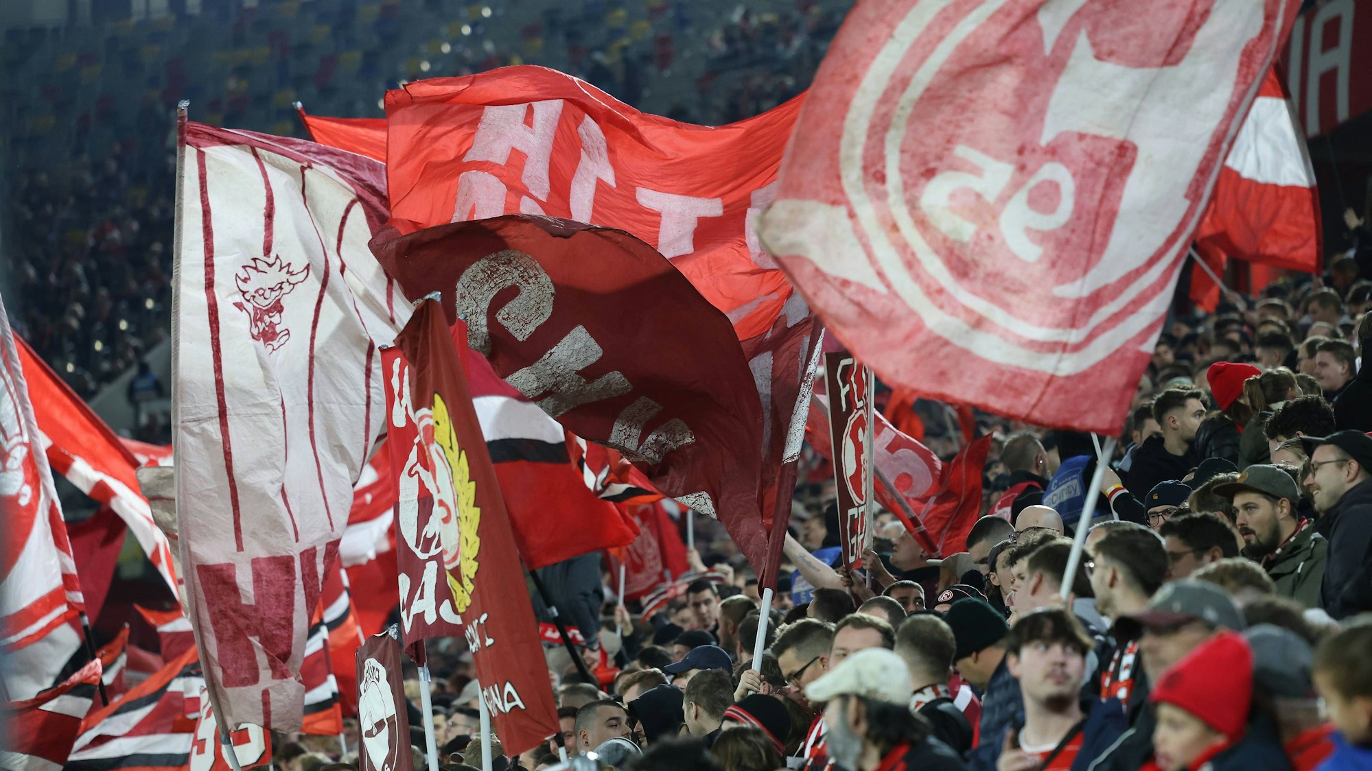 Fans von Fortuna Düsseldorf schwenken beim Heimspiel gegen den SV Wehen Wiesbaden ihre Fahnen.