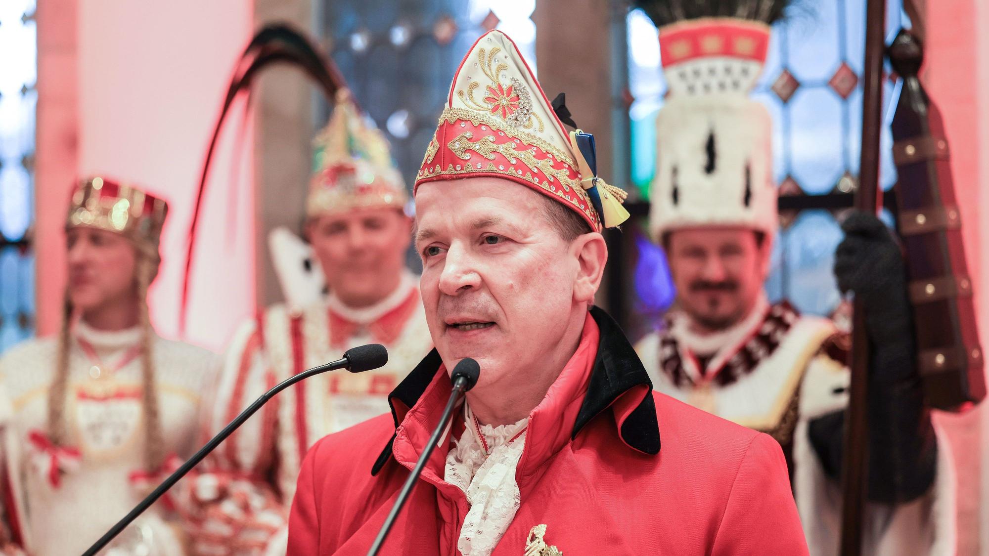 Christoph Kuckelkorn steht in Karnevalstracht vor einem Mikrofon und hält eine Rede.