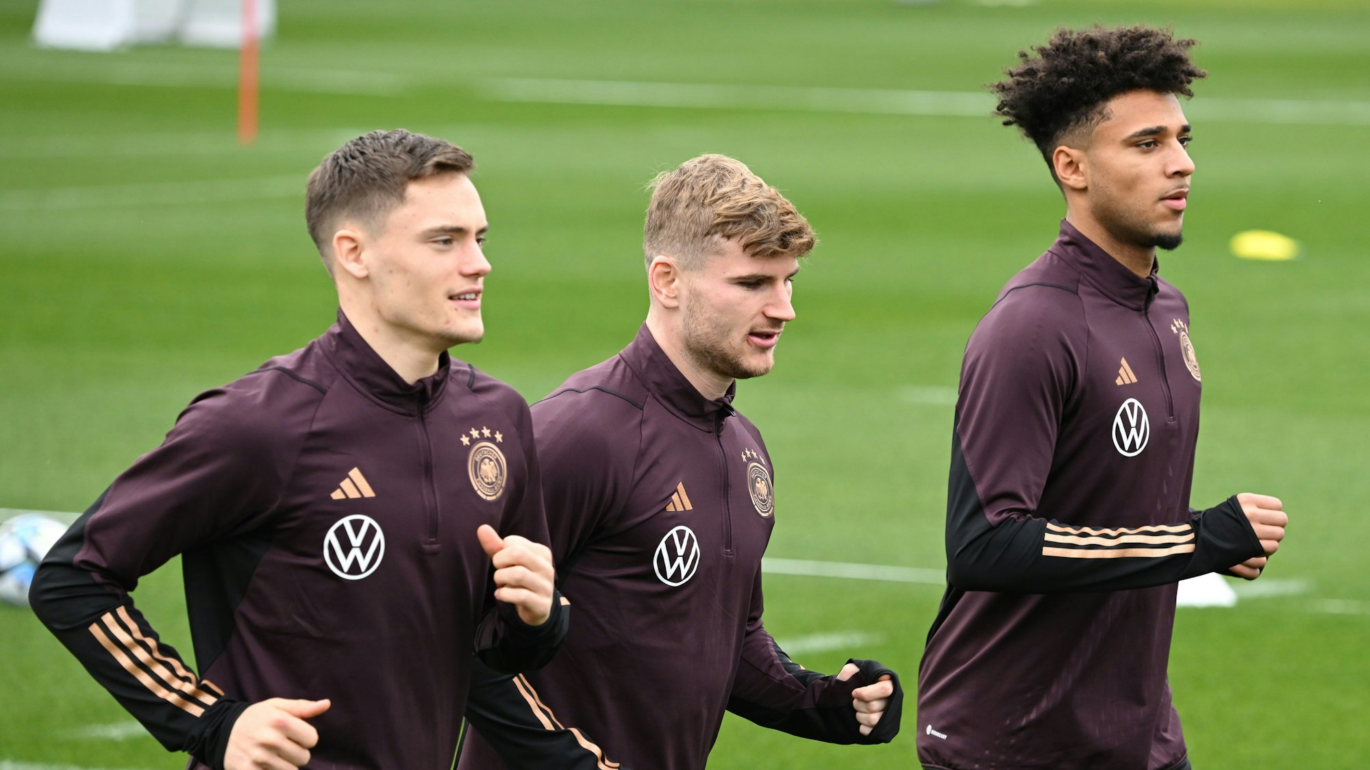 Florian Wirtz (l-r), Timo Werner und Kevin Schade laufen beim Training der Nationalmannschaft auf dem Trainingsplatz des DFB-Campus.