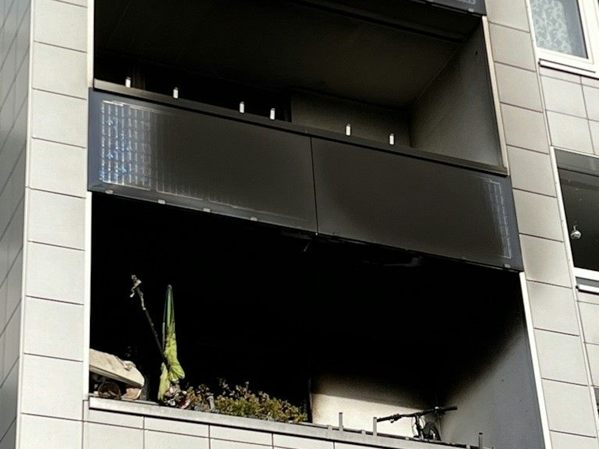 Zwei übereinanderliegende Balkone sind rußgeschwärzt.