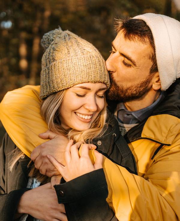 Hiker kissing his girlfriend on a head