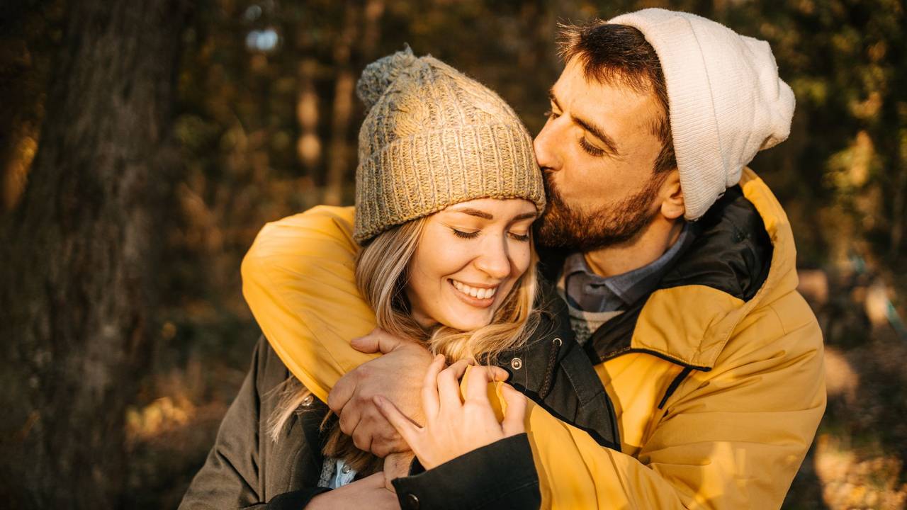 Hiker kissing his girlfriend on a head