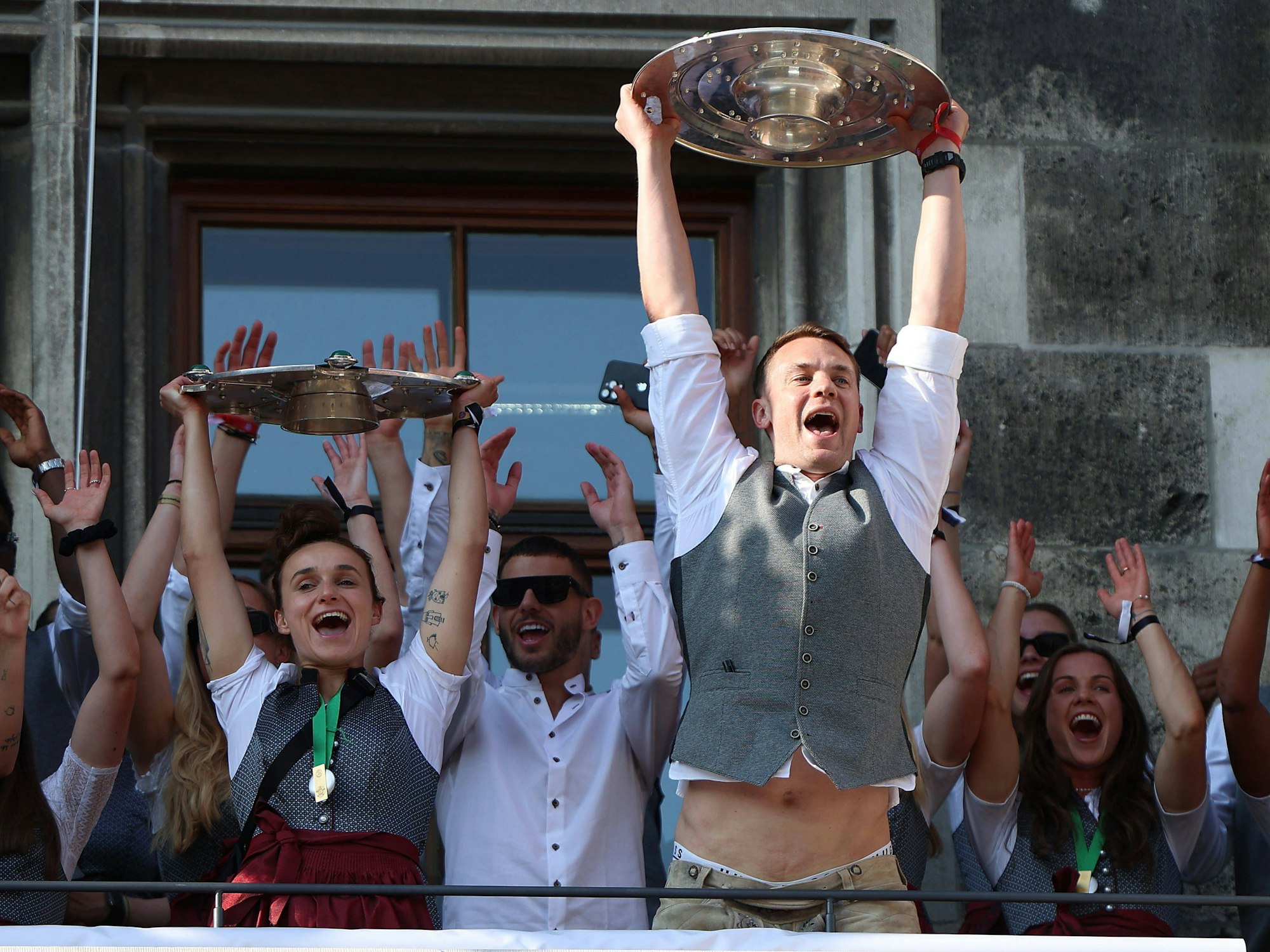 Lina Magull und Manuel Neuer feiern mit Meisterschale und Fans am Marienplatz in München.