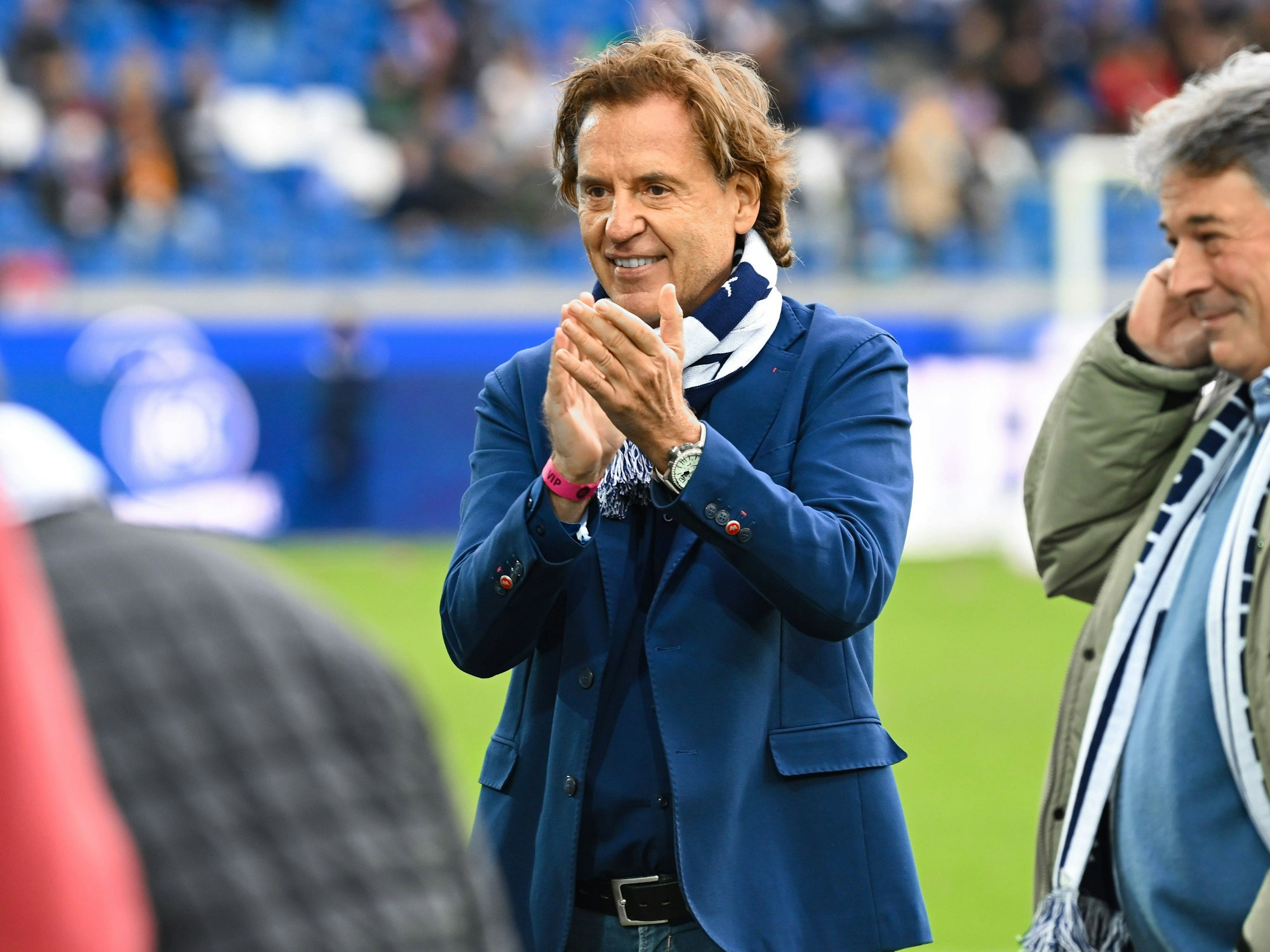 Jörg Dahlmann steht klatschend im Stadion des Karlsruher SC.