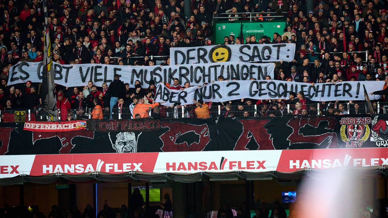 Fans von Bayer Leverkusen halten ein queerfeindliches Plakat hoch