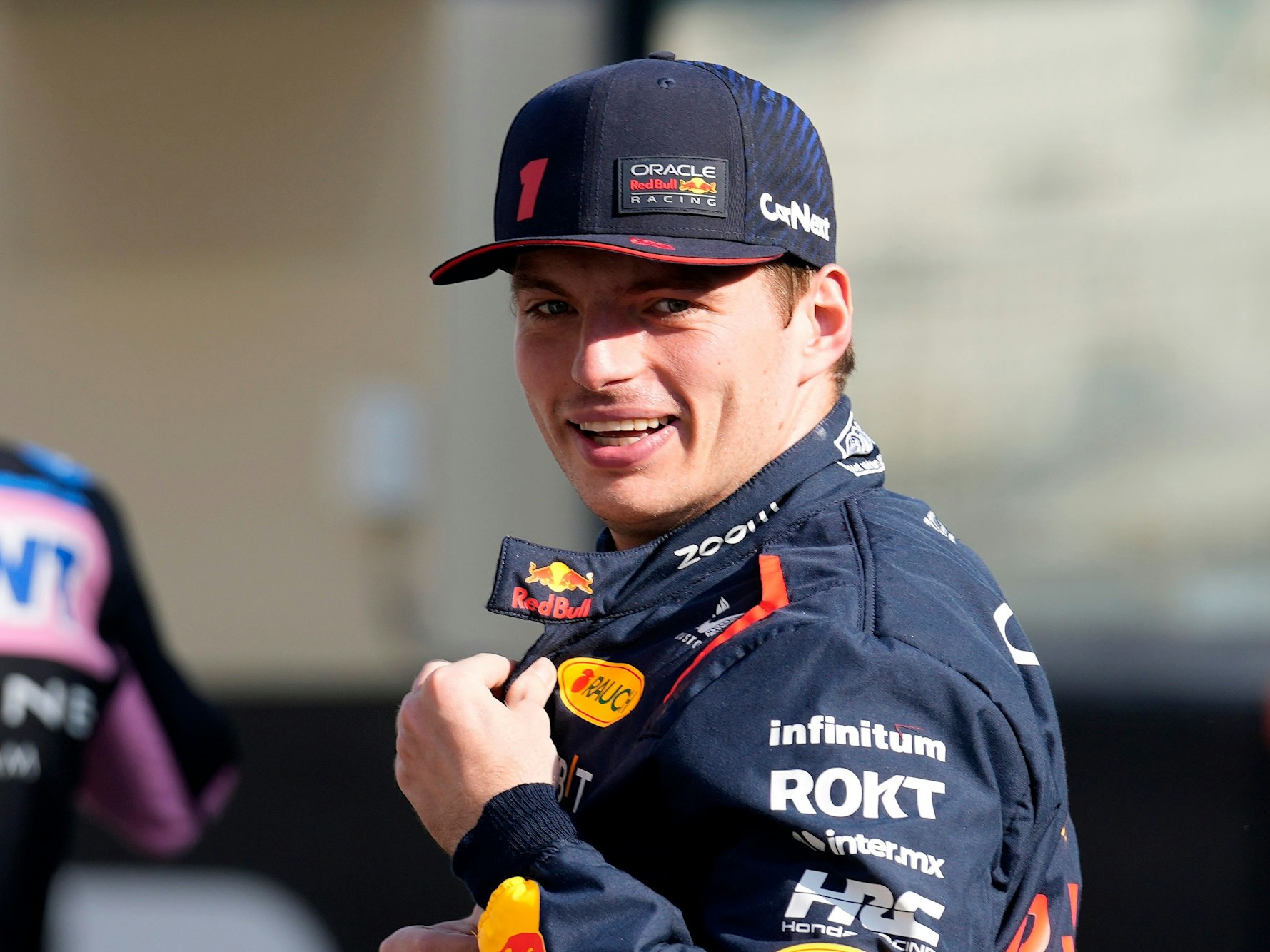 Max Verstappen lacht in die Kamera.