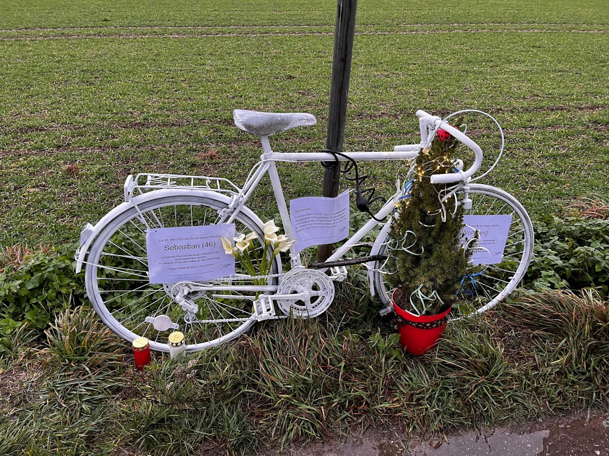 Ein weißes Fahrrad steht an der Straße.