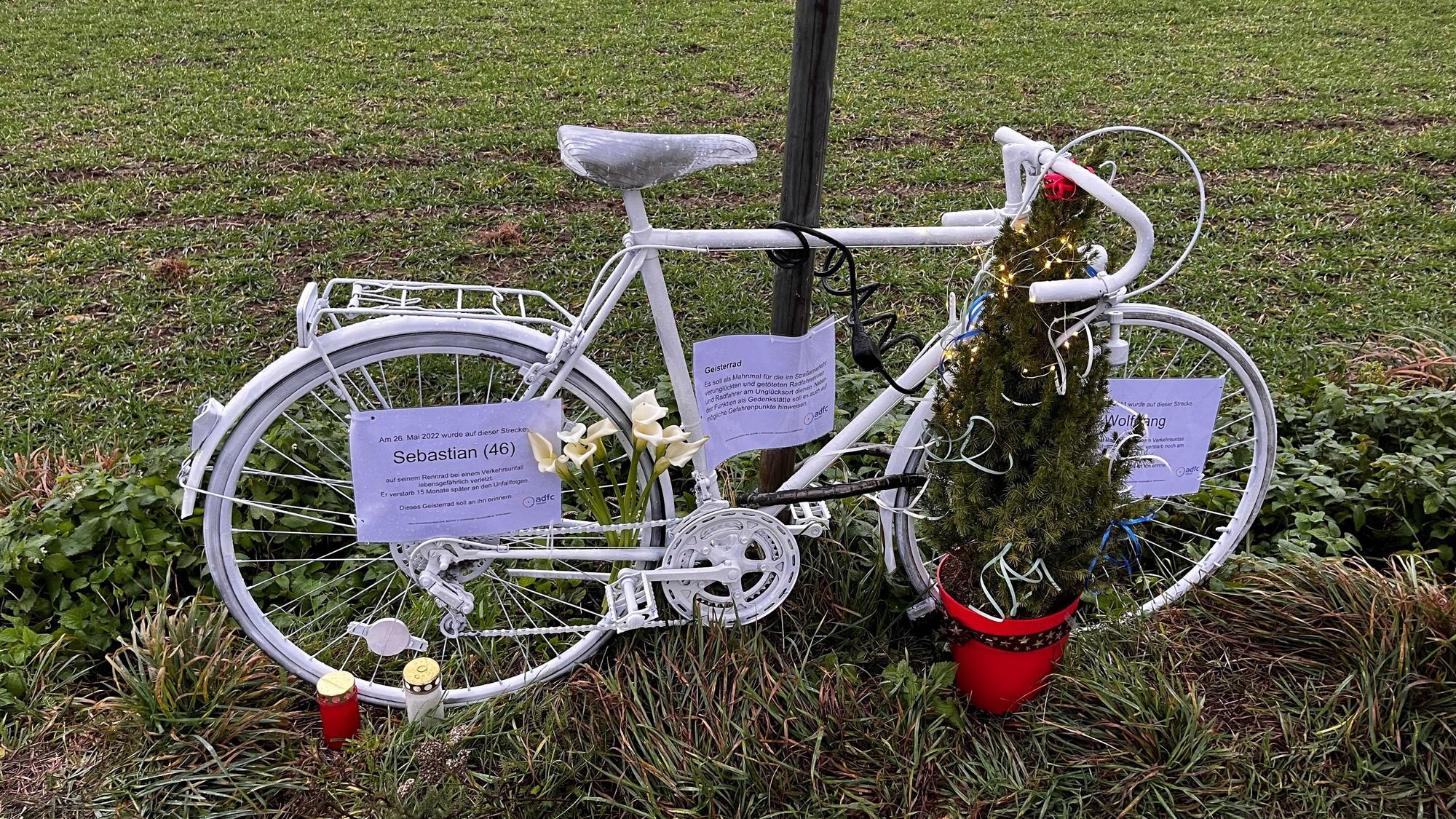 Ein weißes Fahrrad steht an der Straße.