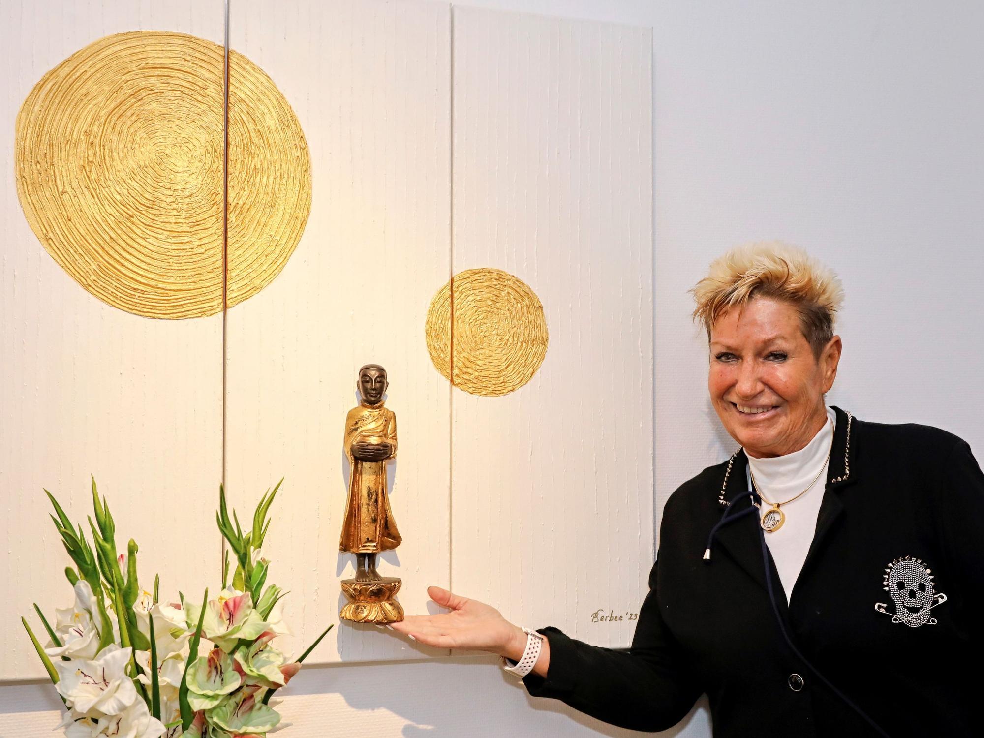 Marita Köllner steht vor einem Bild.