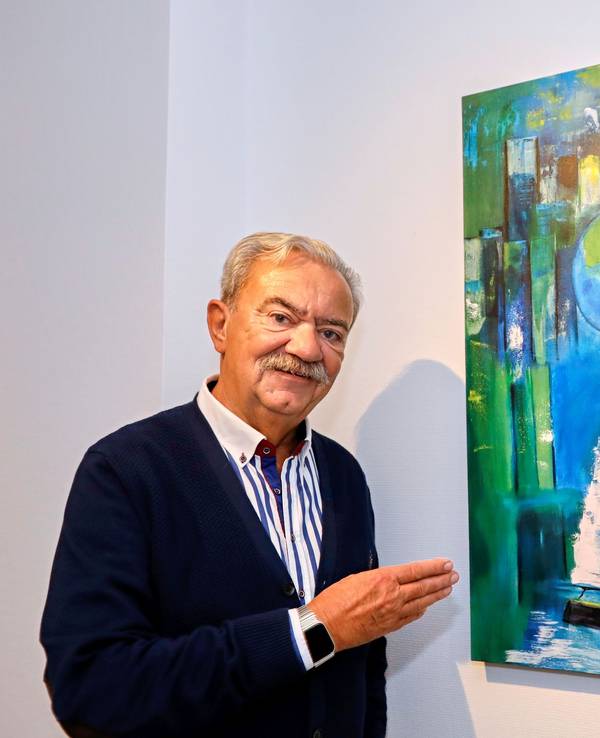Peter Serbee vor einem von ihm gemalten Bild.