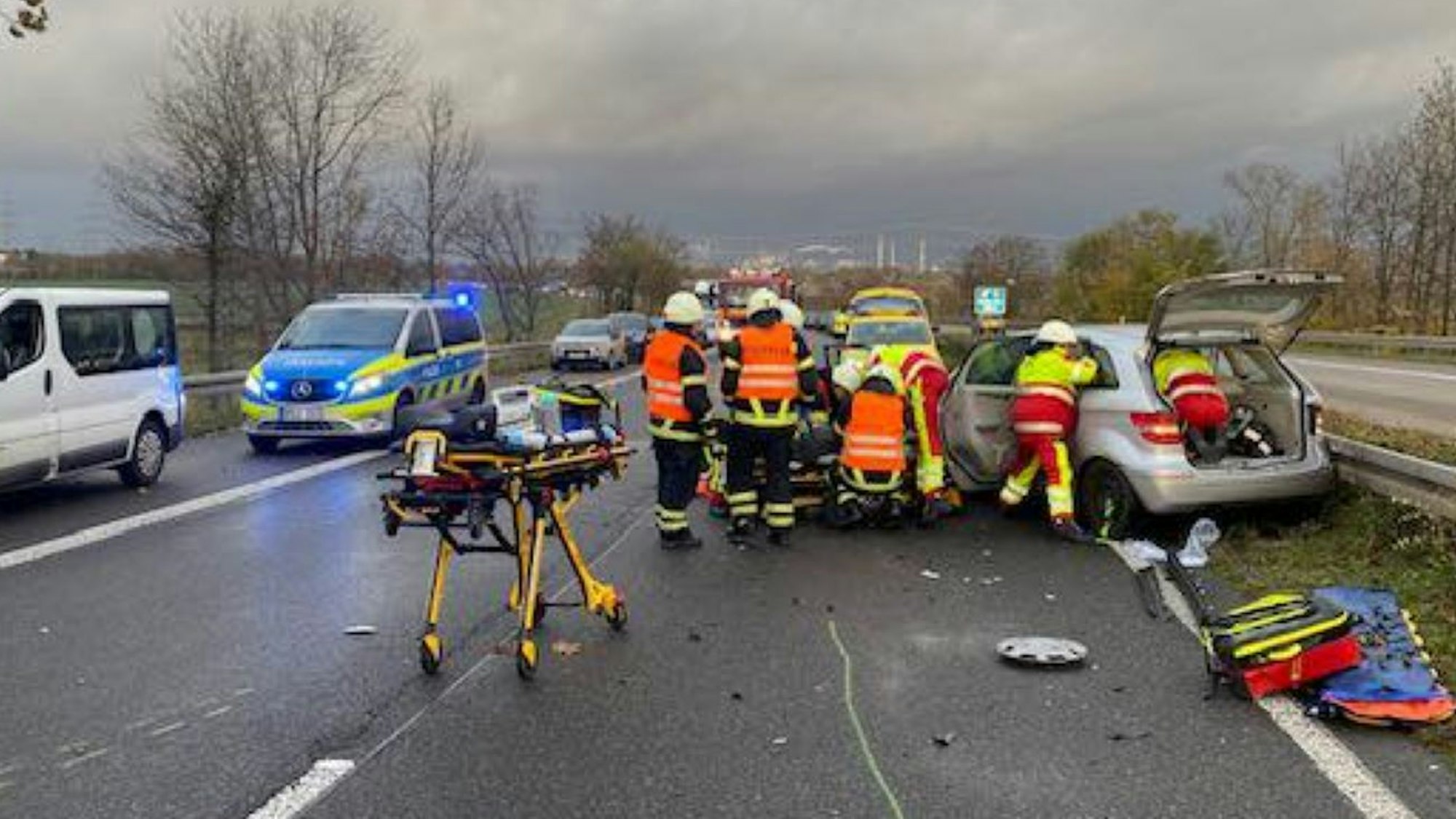 Einsatzkräfte kümmern sich an einem Auto um verletzte Insassen.