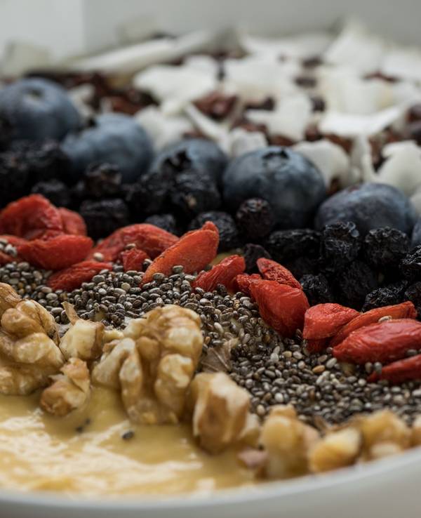 Eine Frühstücksbowl mit Superfoods, Früchten und Nüssen ist zu sehen.