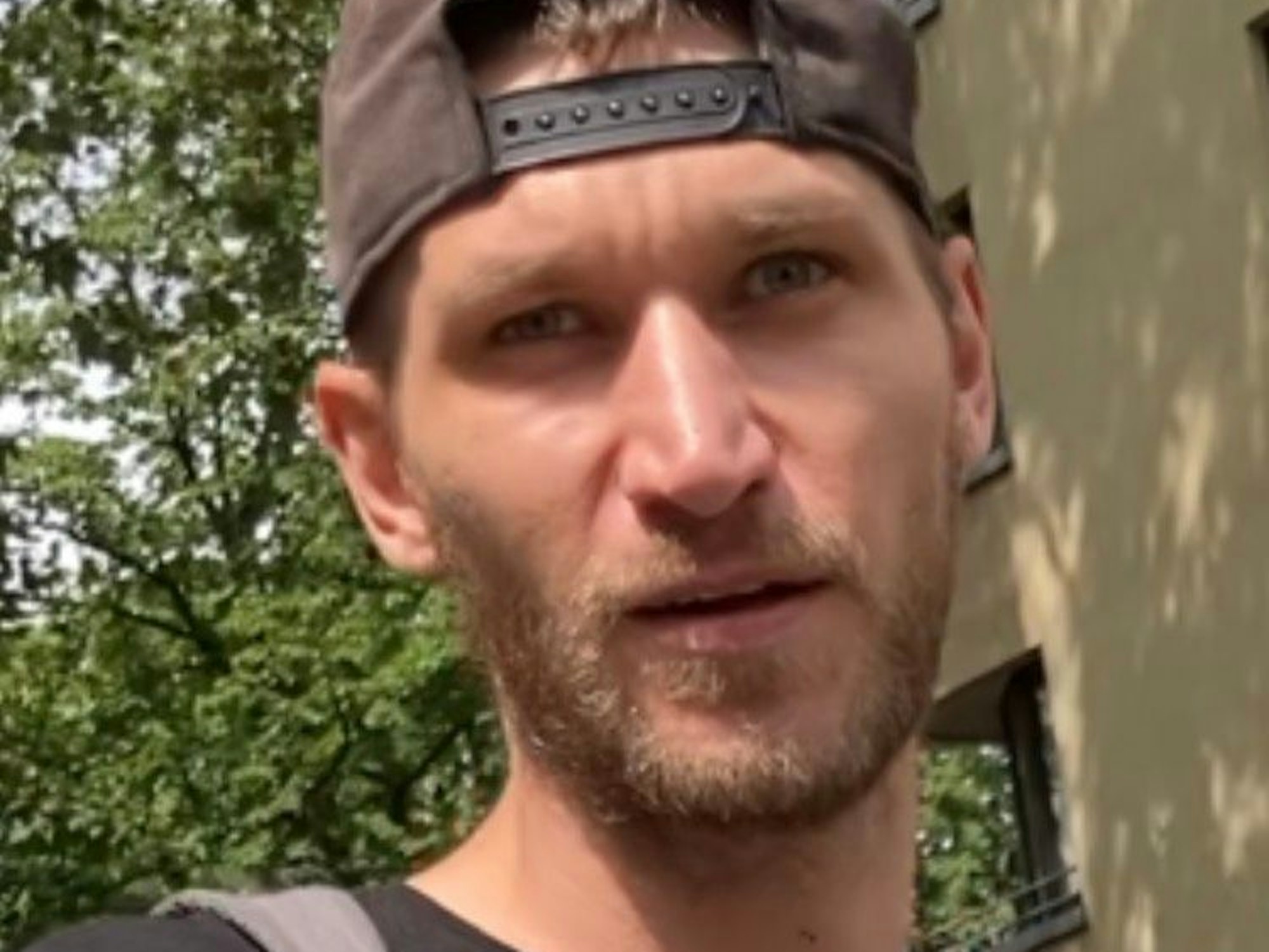 Ein Mann trägt eine Basecap falschherum auf dem Kopf.