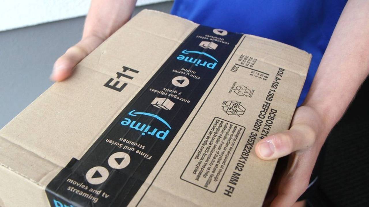 Eine Person hält ein Amazon-Paket in den Händen.