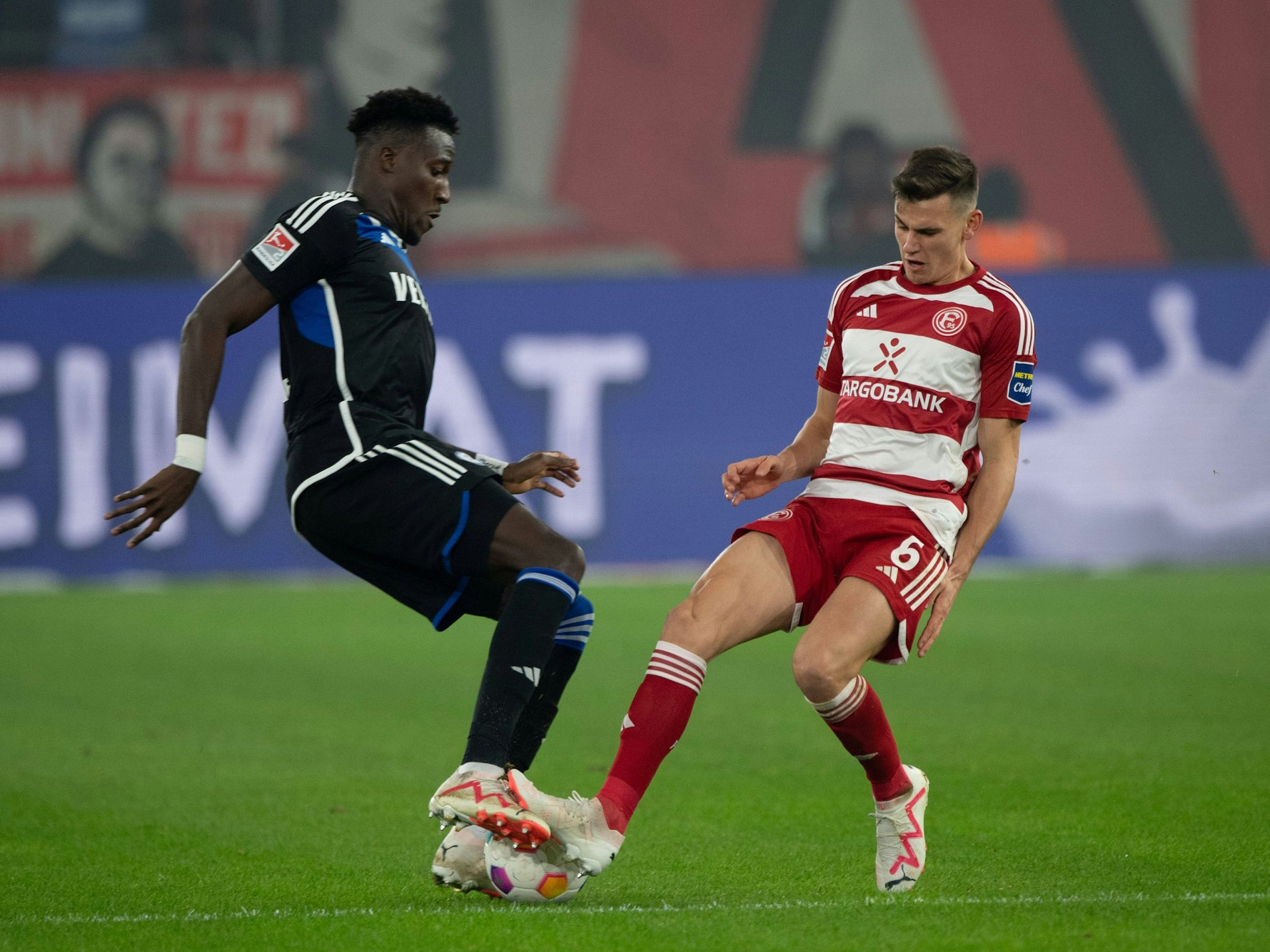 Fortuna Düsseldorfs Yannik Engelhardt im Zweikampf mit Schalkes Bryan Lasme.