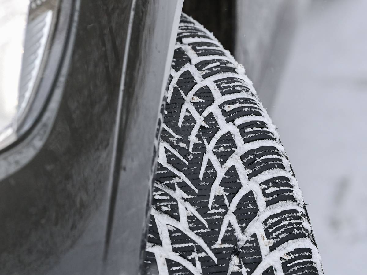 Das Profil eines Winterreifens auf einem Pkw hat sich vom Schnee auf der Fahrbahn zugesetzt, hier im Dezember 2021.