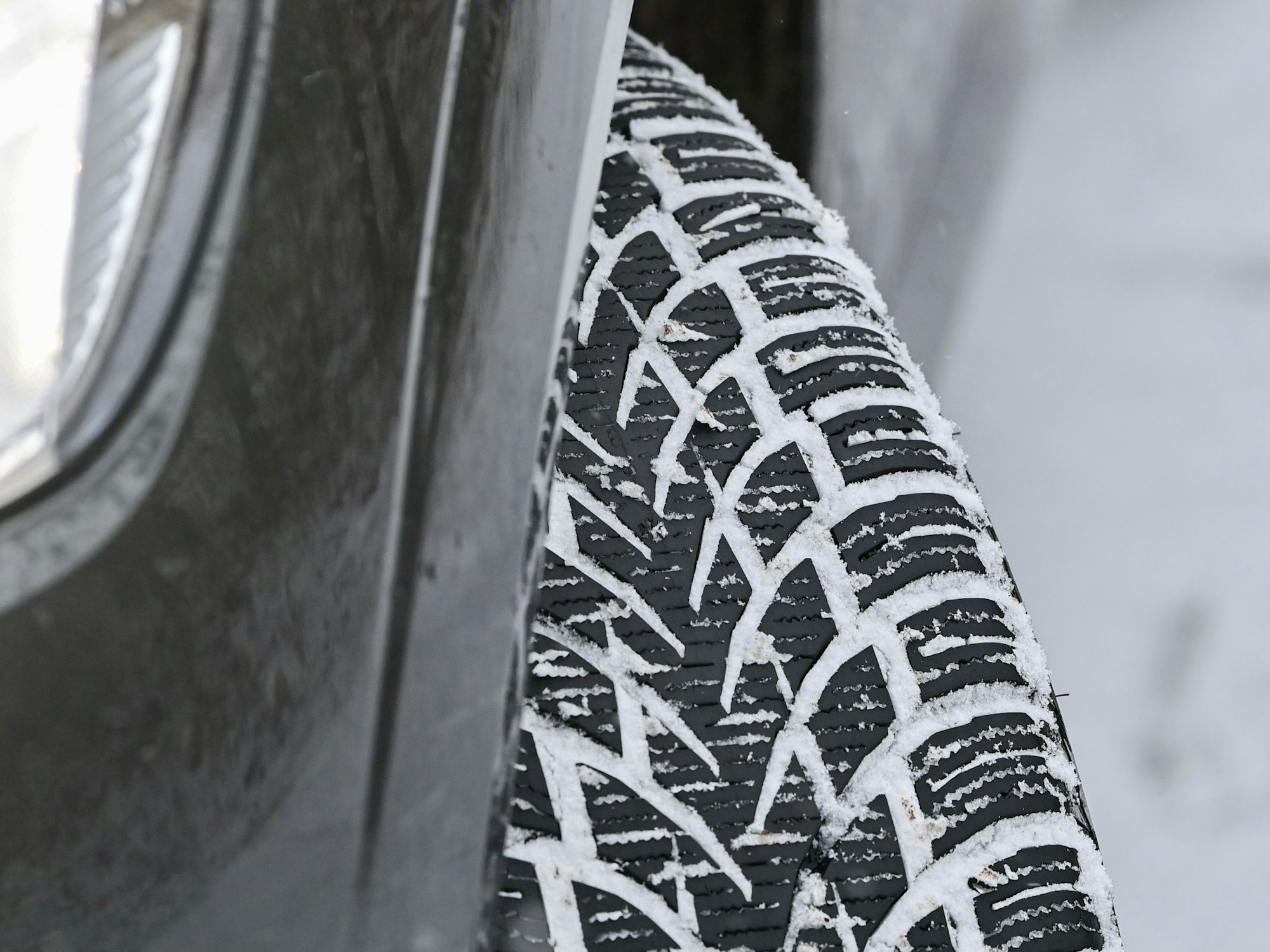 Das Profil eines Winterreifens auf einem Pkw hat sich vom Schnee auf der Fahrbahn zugesetzt, hier im Dezember 2021.