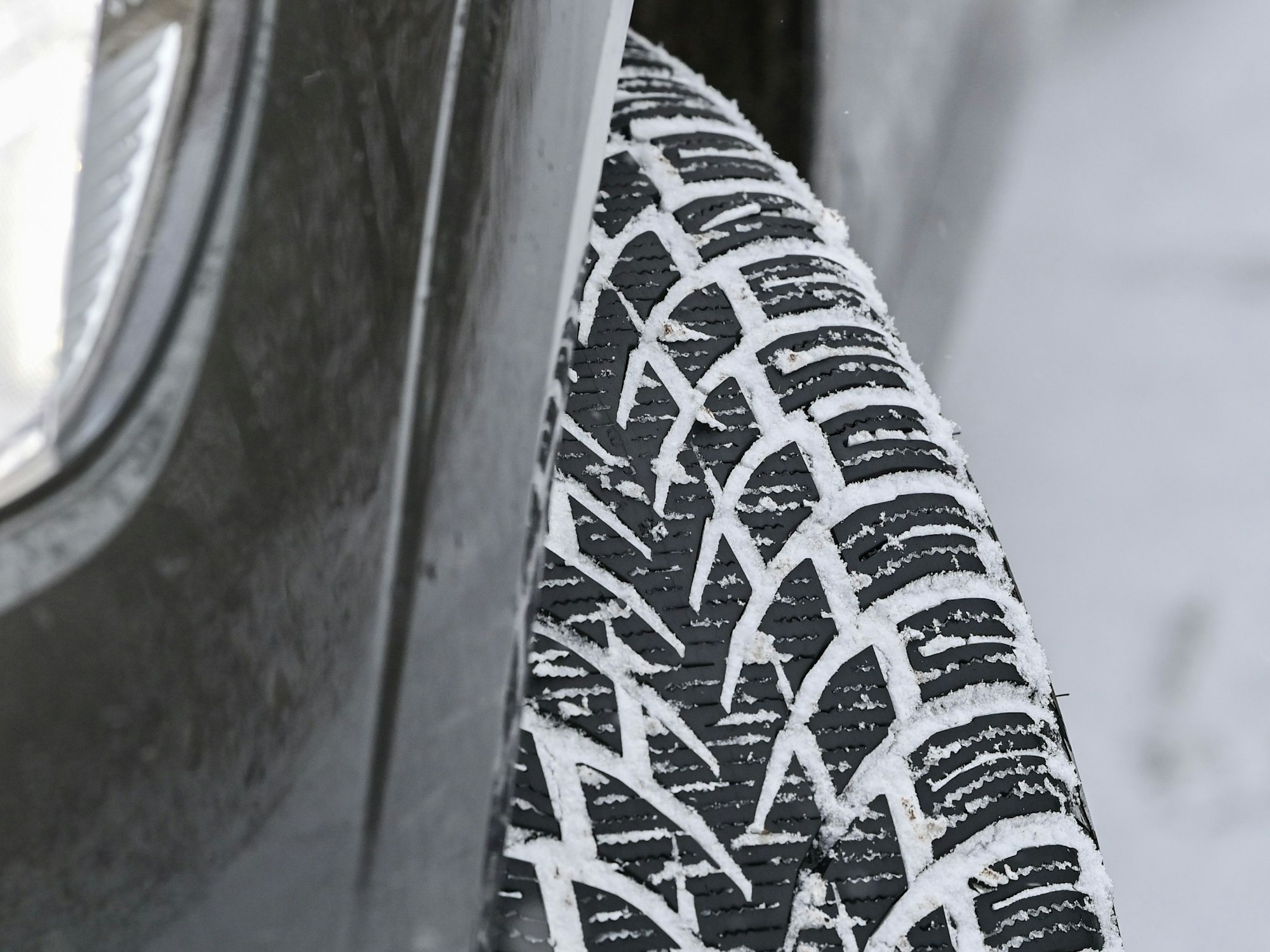 Das Profil eines Winterreifens auf einem Pkw hat sich vom Schnee auf der Fahrbahn zugesetzt, hier im Dezember 2021.