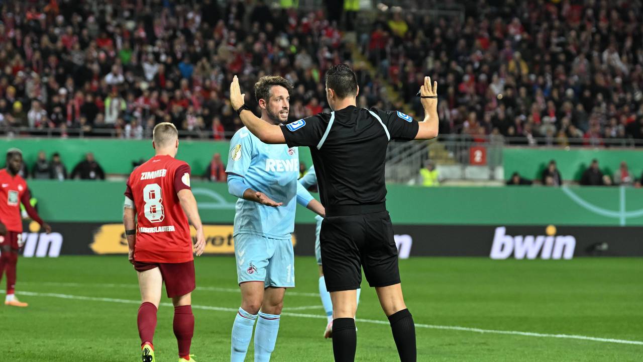 Schiedsrichter Sven Jablonski im DFB-Pokalspiel zwischen dem 1. FC Kaiserslautern und dem 1. FC Köln im Gespräch mit Gäste-Profi Mark Uth.