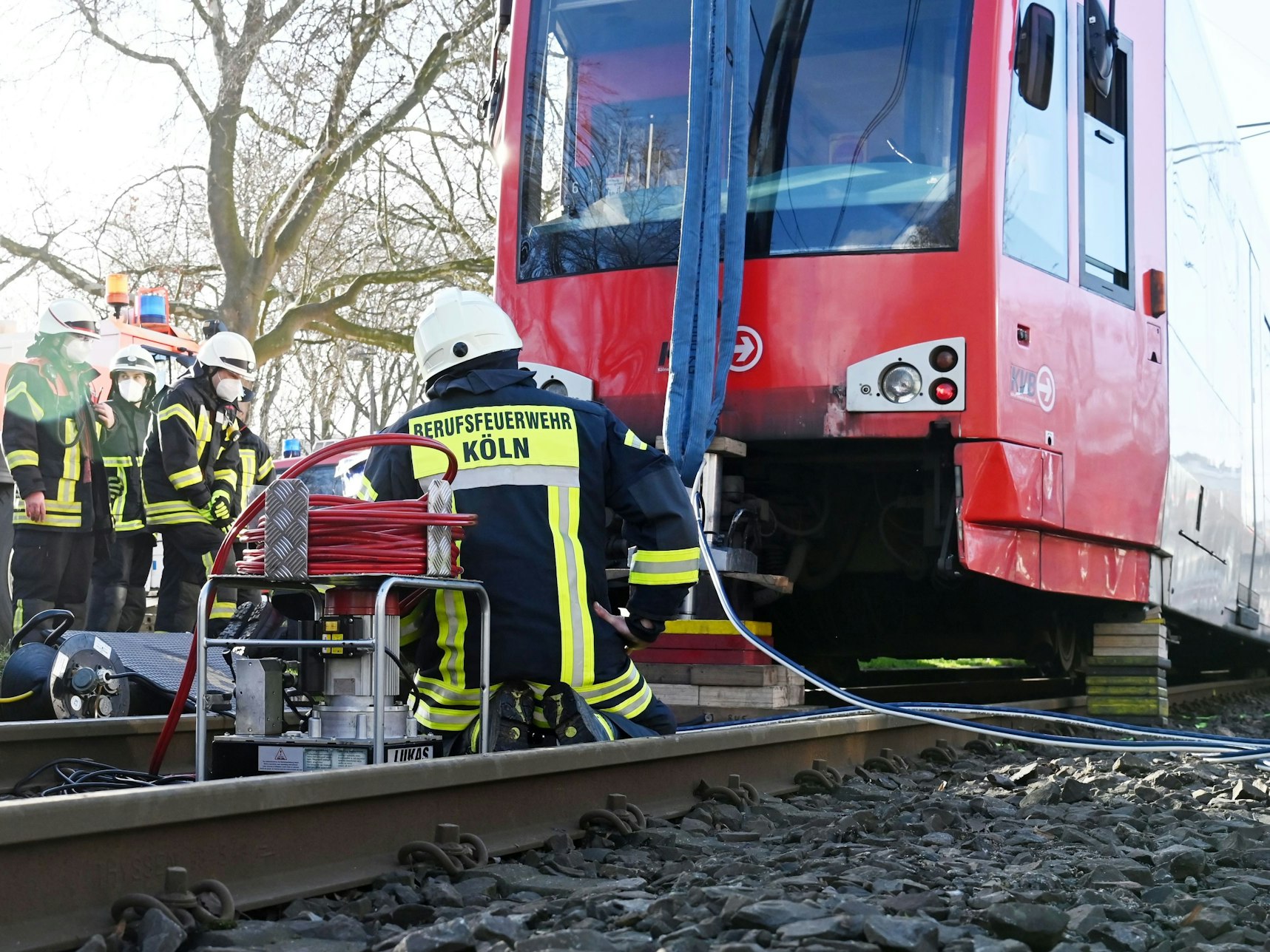 Feuerwehrleute sitzen vor einer verunfallten Bahn der KVB.