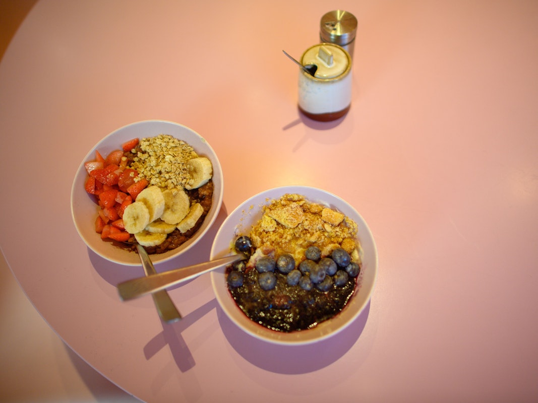 Bowls, die unter anderem Erdbeeren, Bananen und Blaubeeren enthalten.